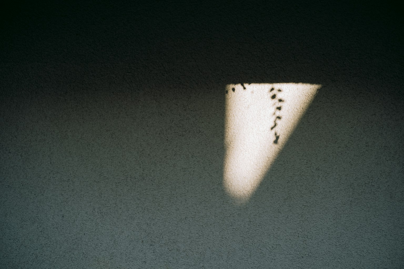 Triangle de lumière sur un fond sombre avec de petits points au-dessus