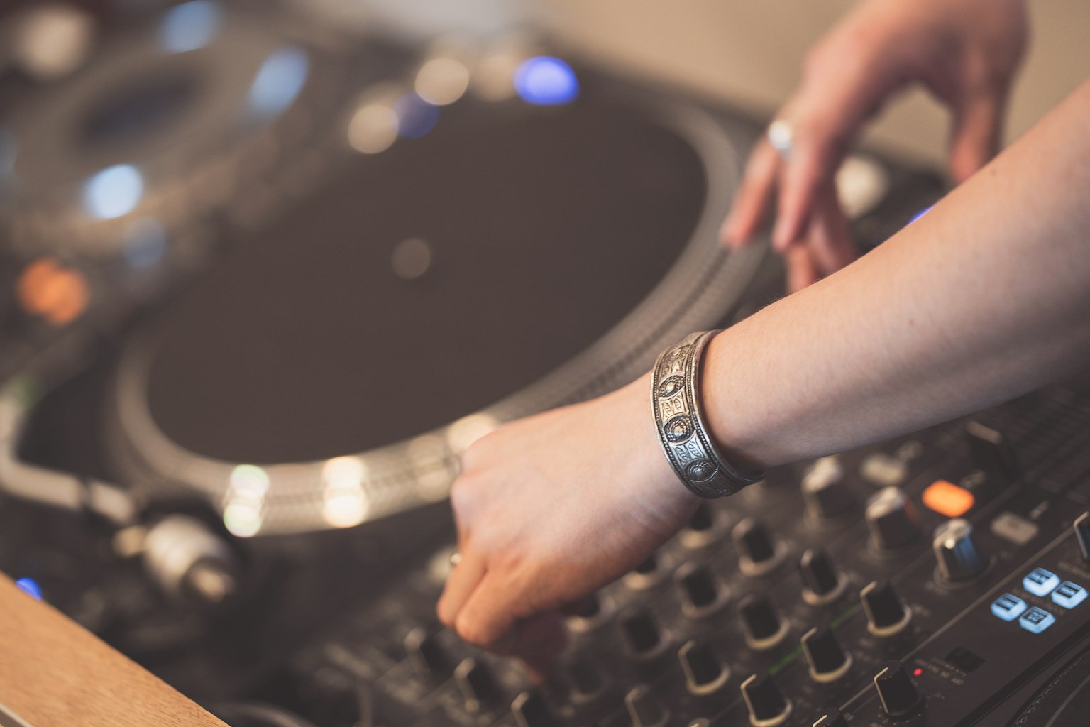 Primo piano delle mani di un DJ che regolano un giradischi