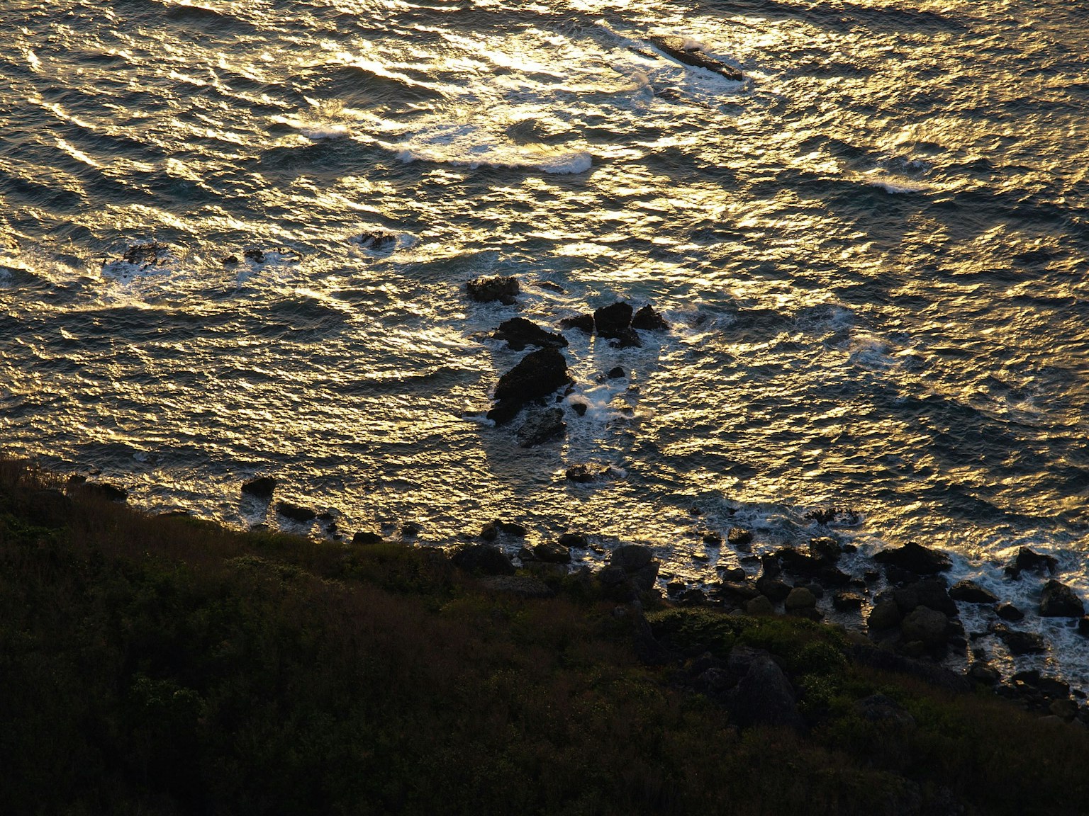 Olas en el mar con formaciones rocosas y sus sombras
