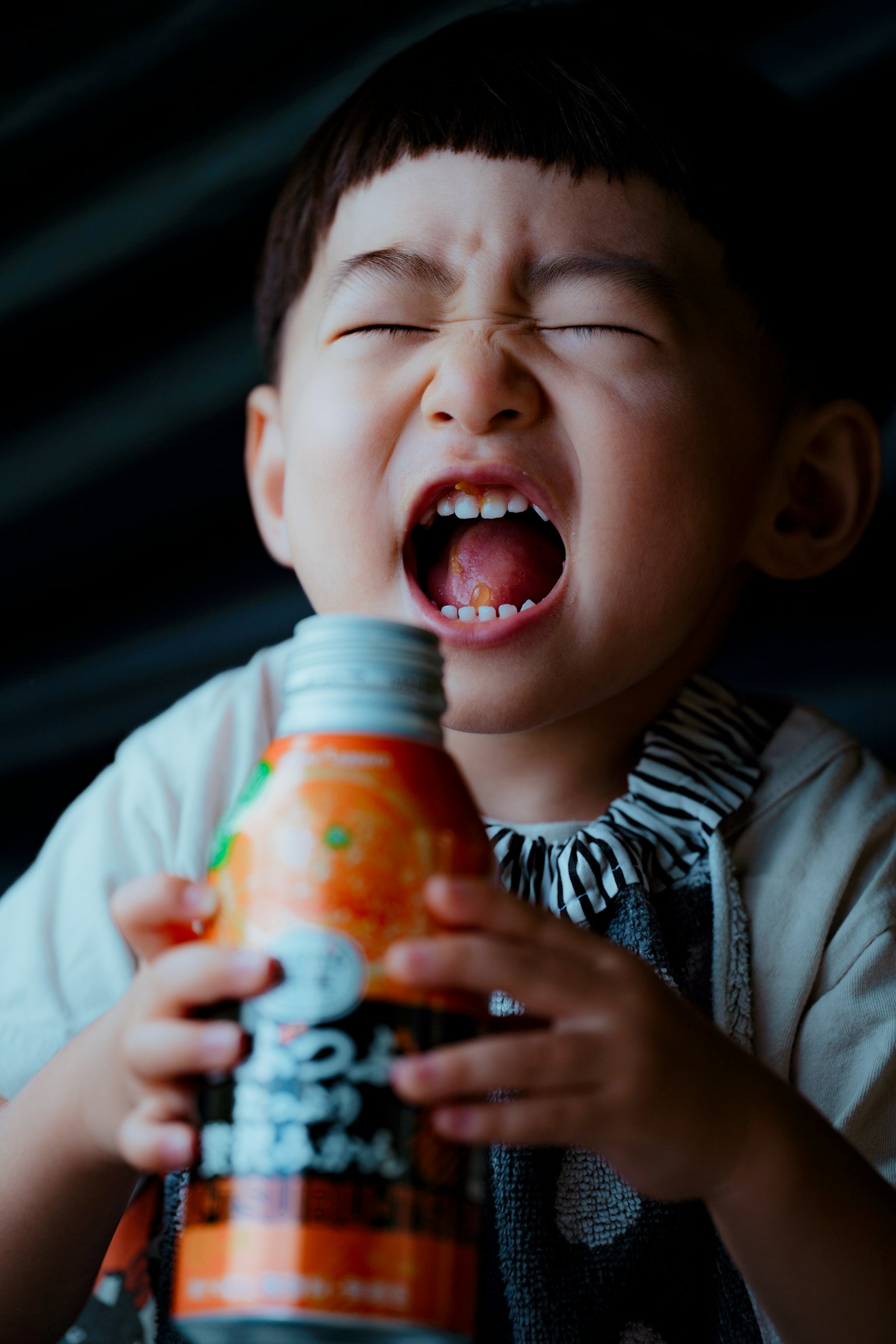 Child yelling while holding a drink bottle
