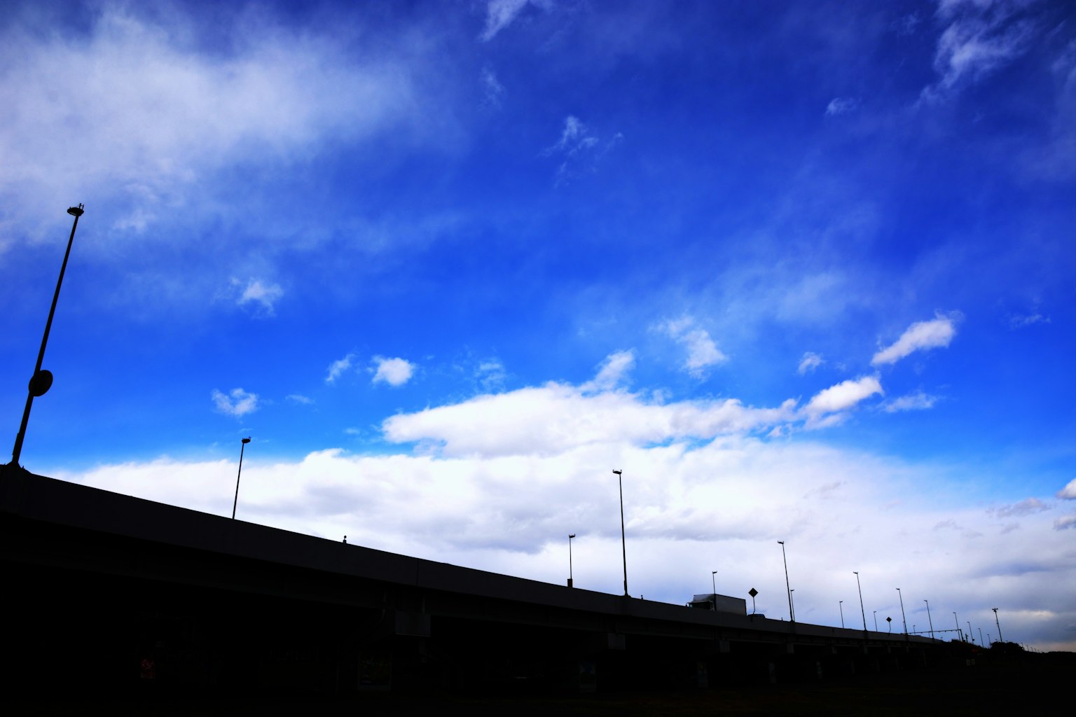 Ciel bleu brillant avec des nuages blancs silhouette d'une autoroute