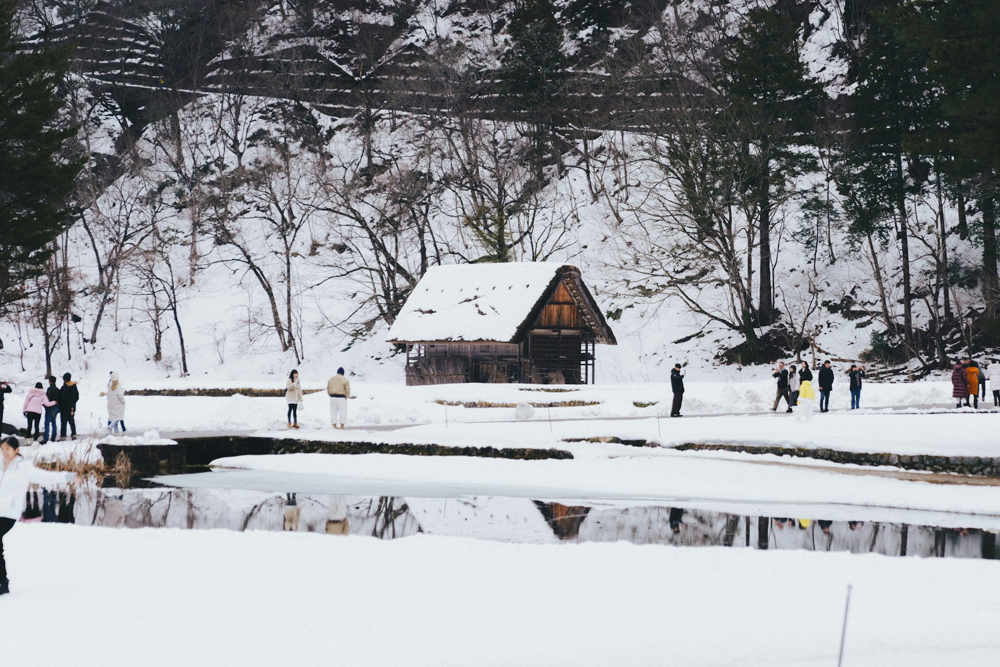 雪の白川郷で囲炉裏のある合掌造りの家と雪景色の小道