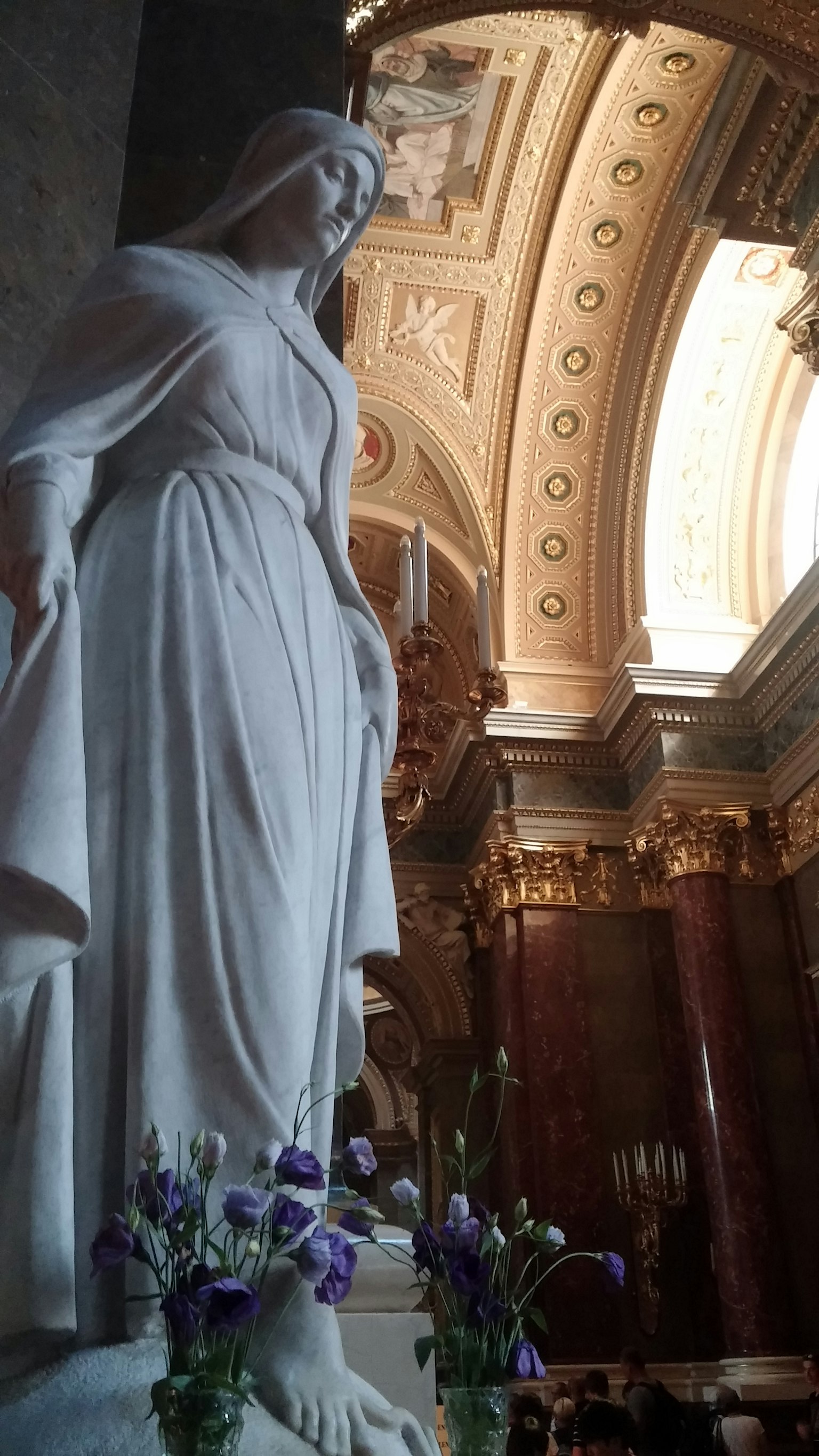 Estatua de mármol con flores en el interior de una iglesia