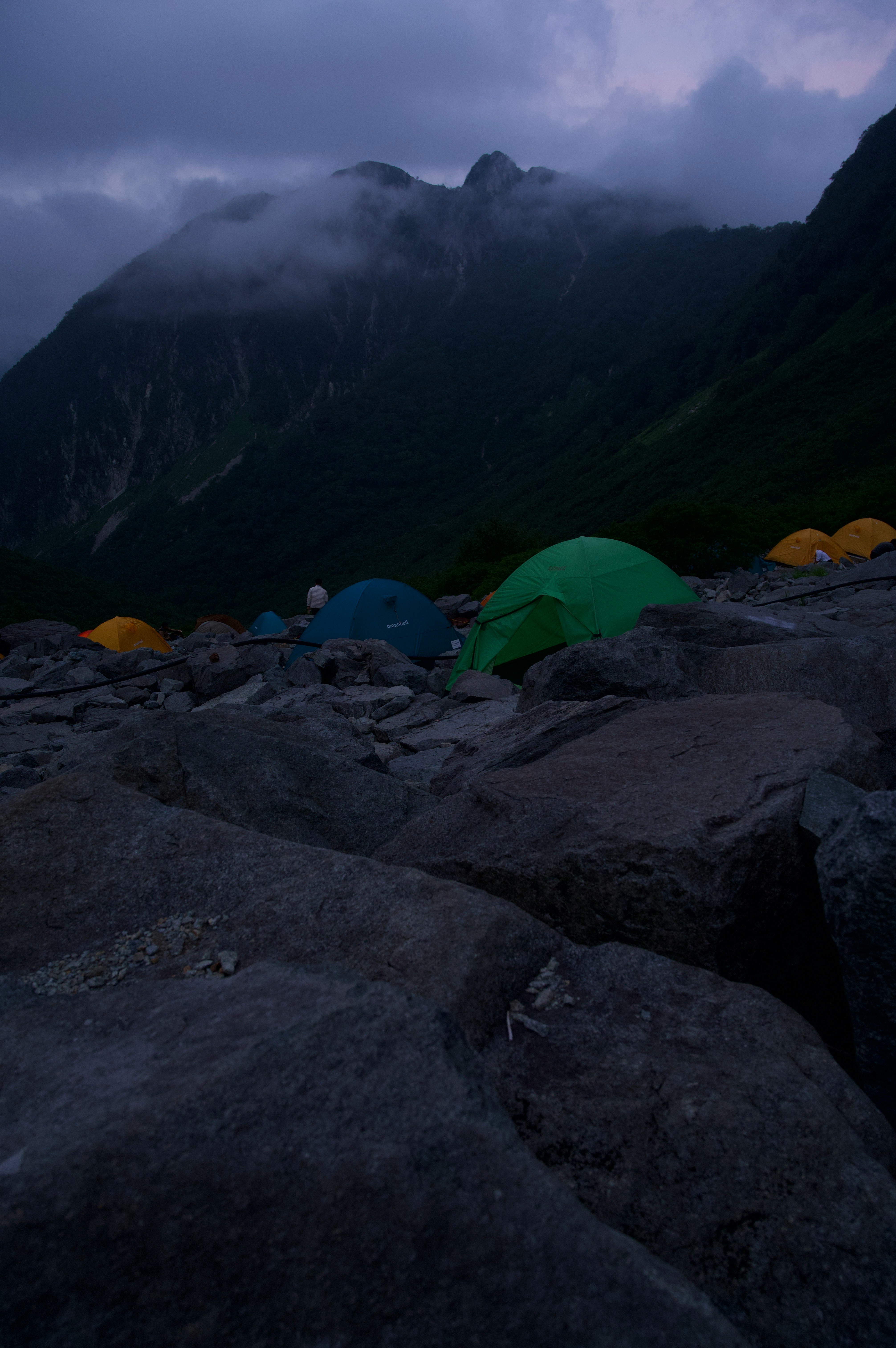 nächtliches Bergcamping mit Zelten auf felsigem Boden