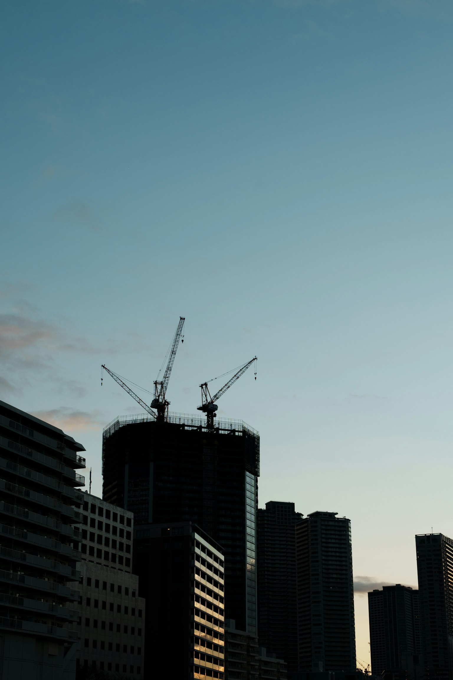 黄昏天空下的建筑和起重机轮廓