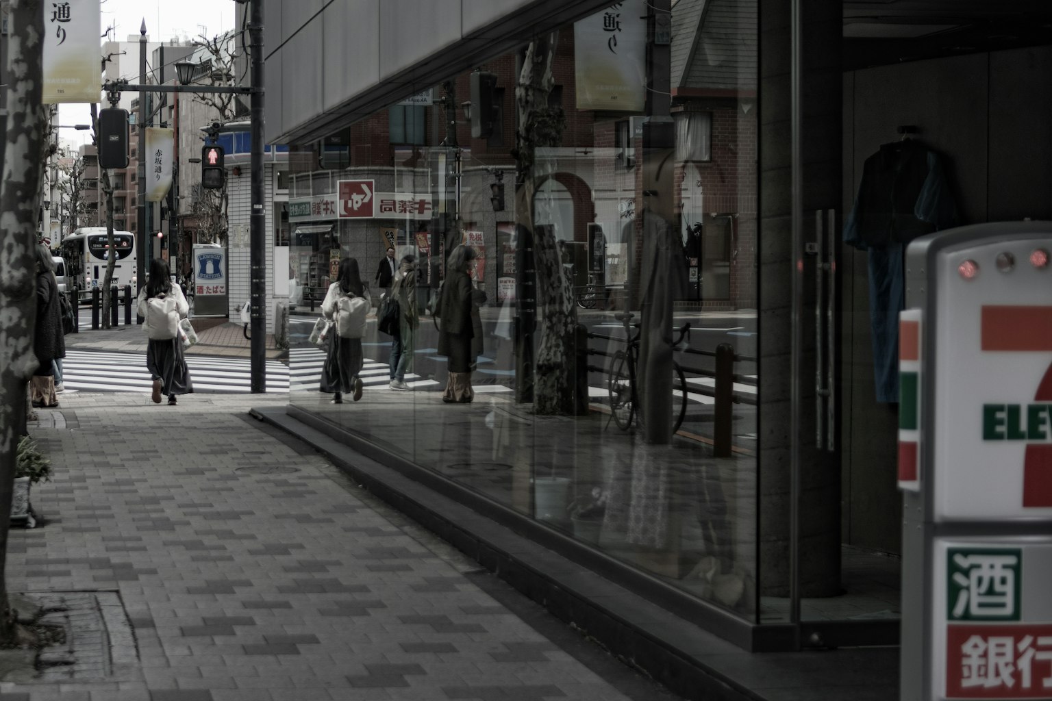 Street corner scene with reflections of buildings and pedestrians