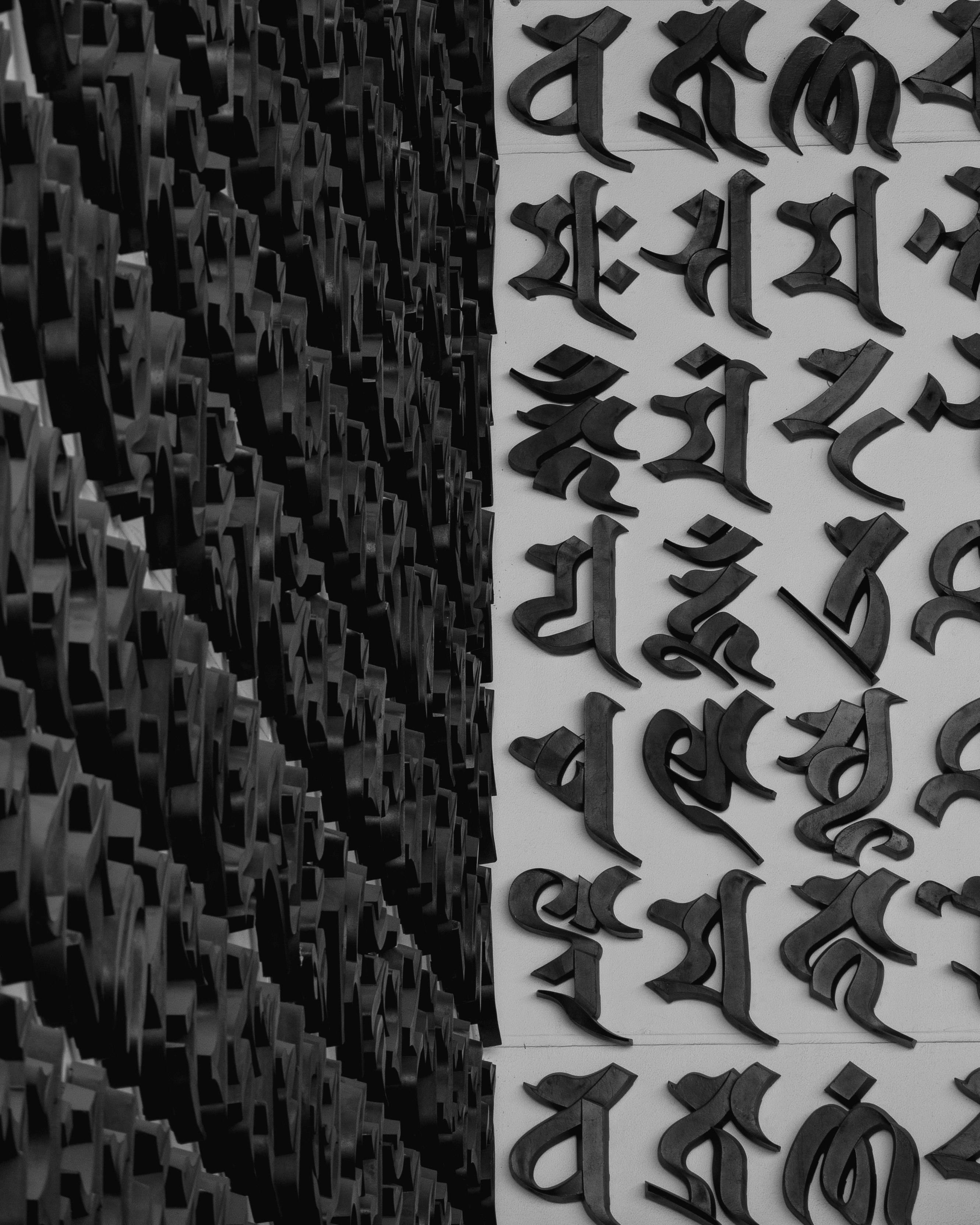 mur monochrome recouvert de symboles de lettres sculptés