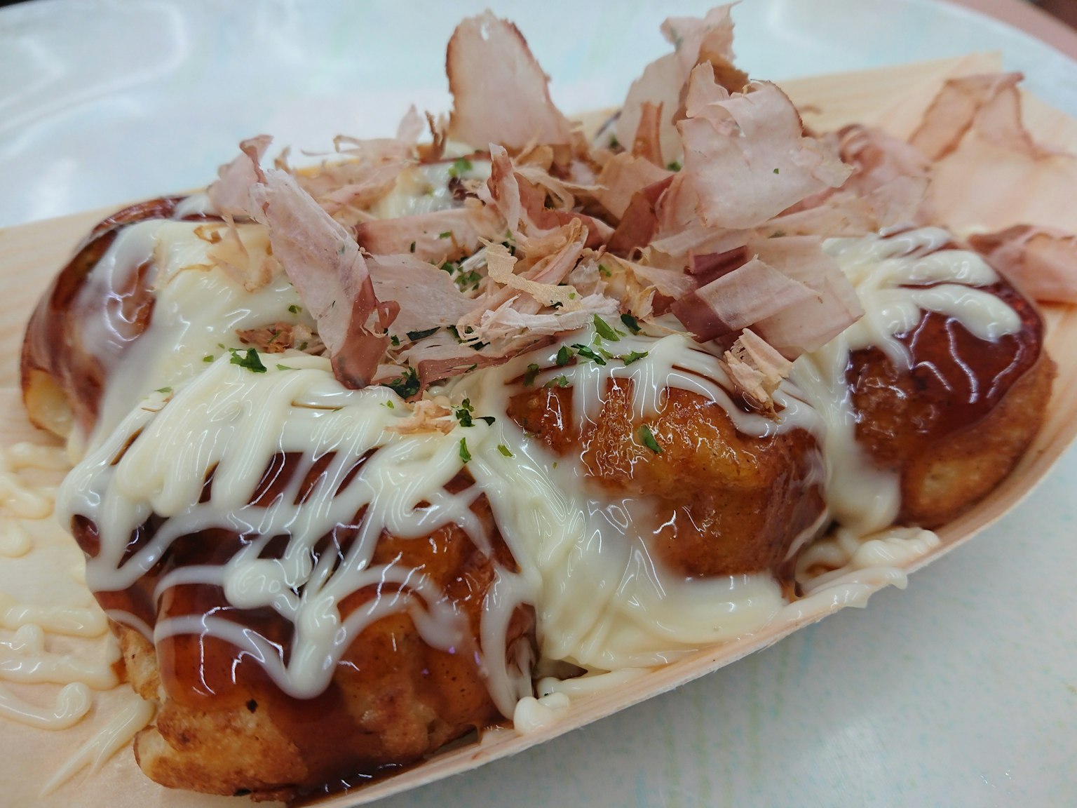 Assiette de takoyaki garnie de mayonnaise et de flocons de bonito