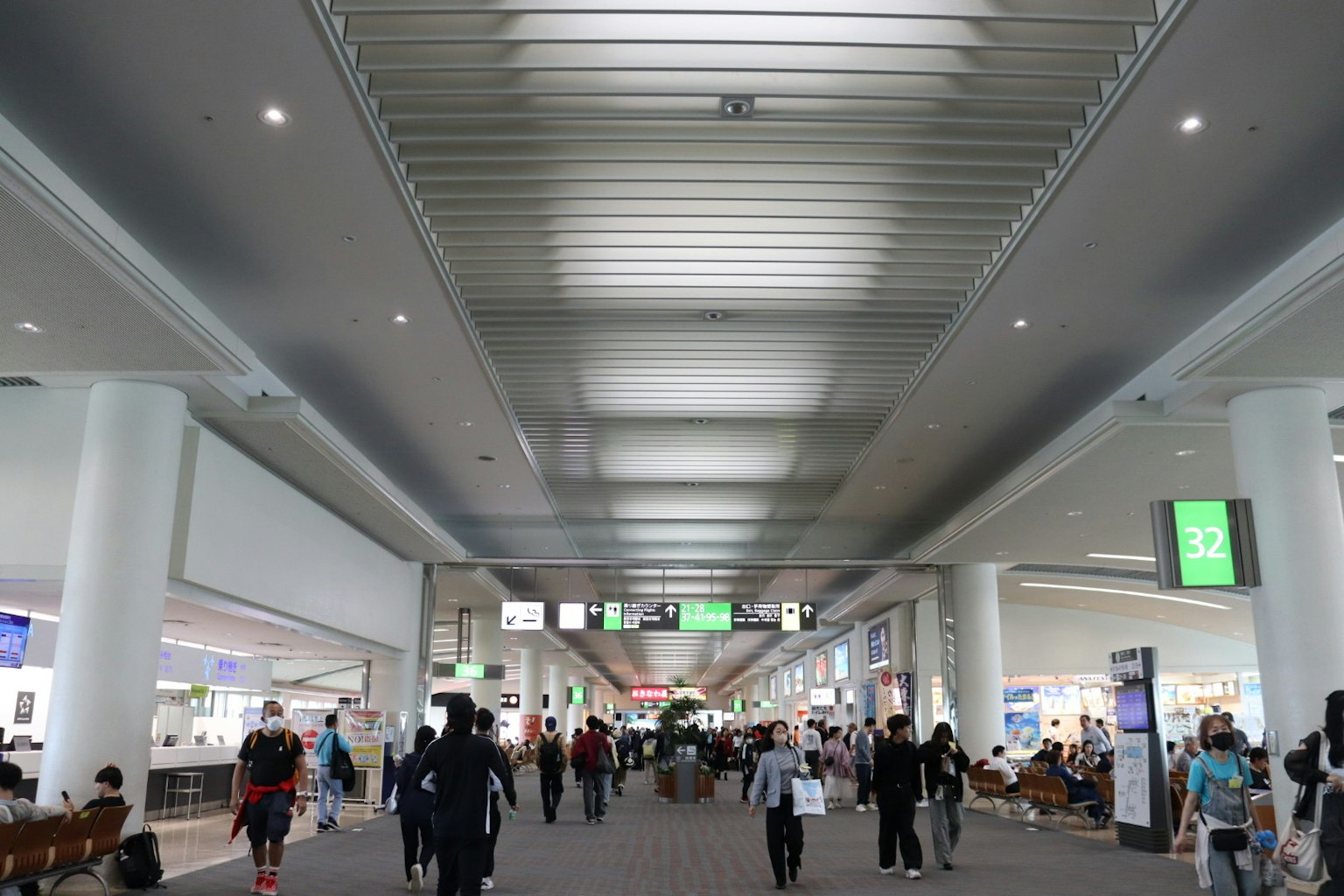 Intérieur d'aéroport spacieux avec un plafond lumineux et de nombreuses personnes marchant