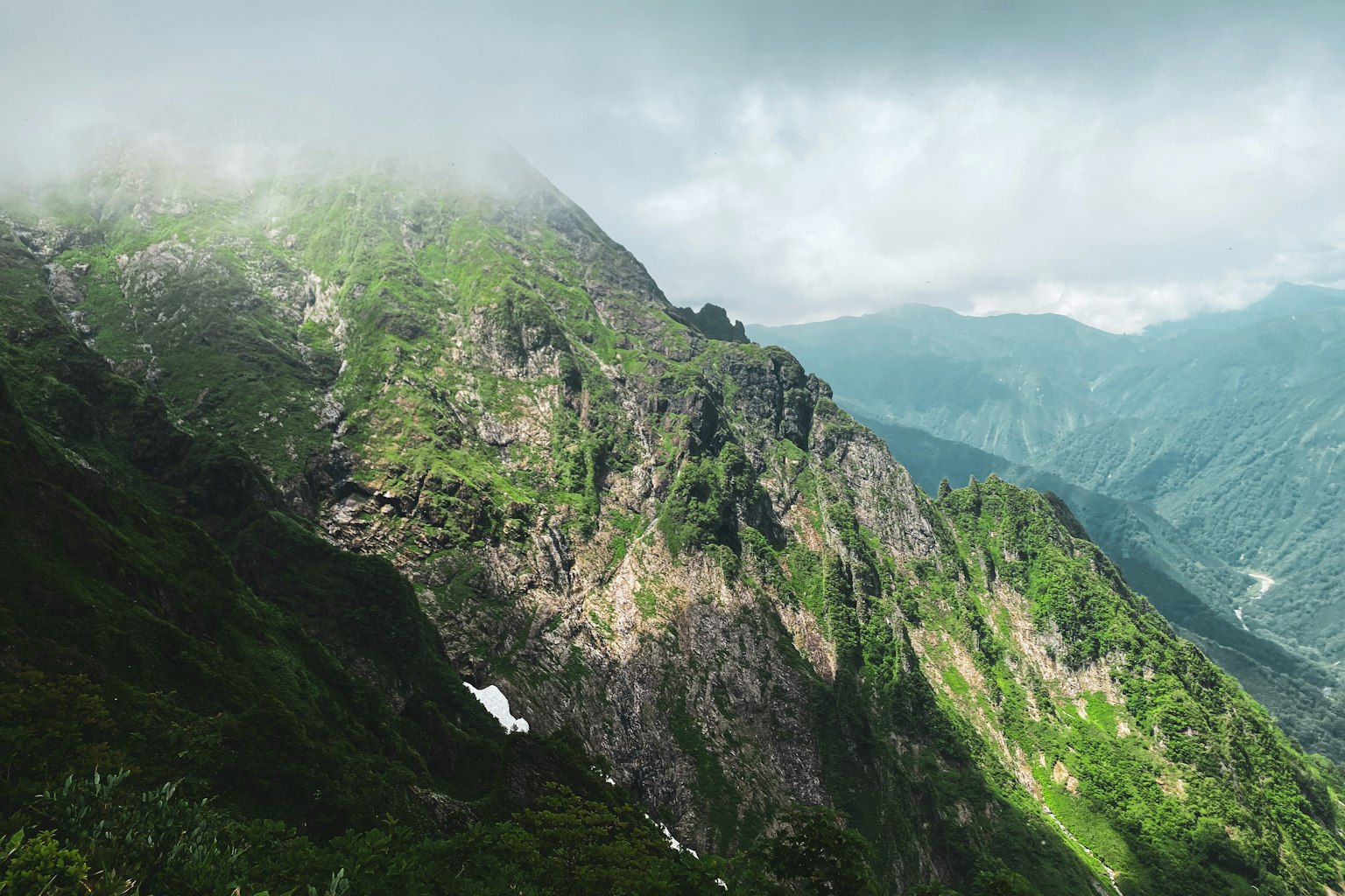 Mist-covered lush green mountain landscape