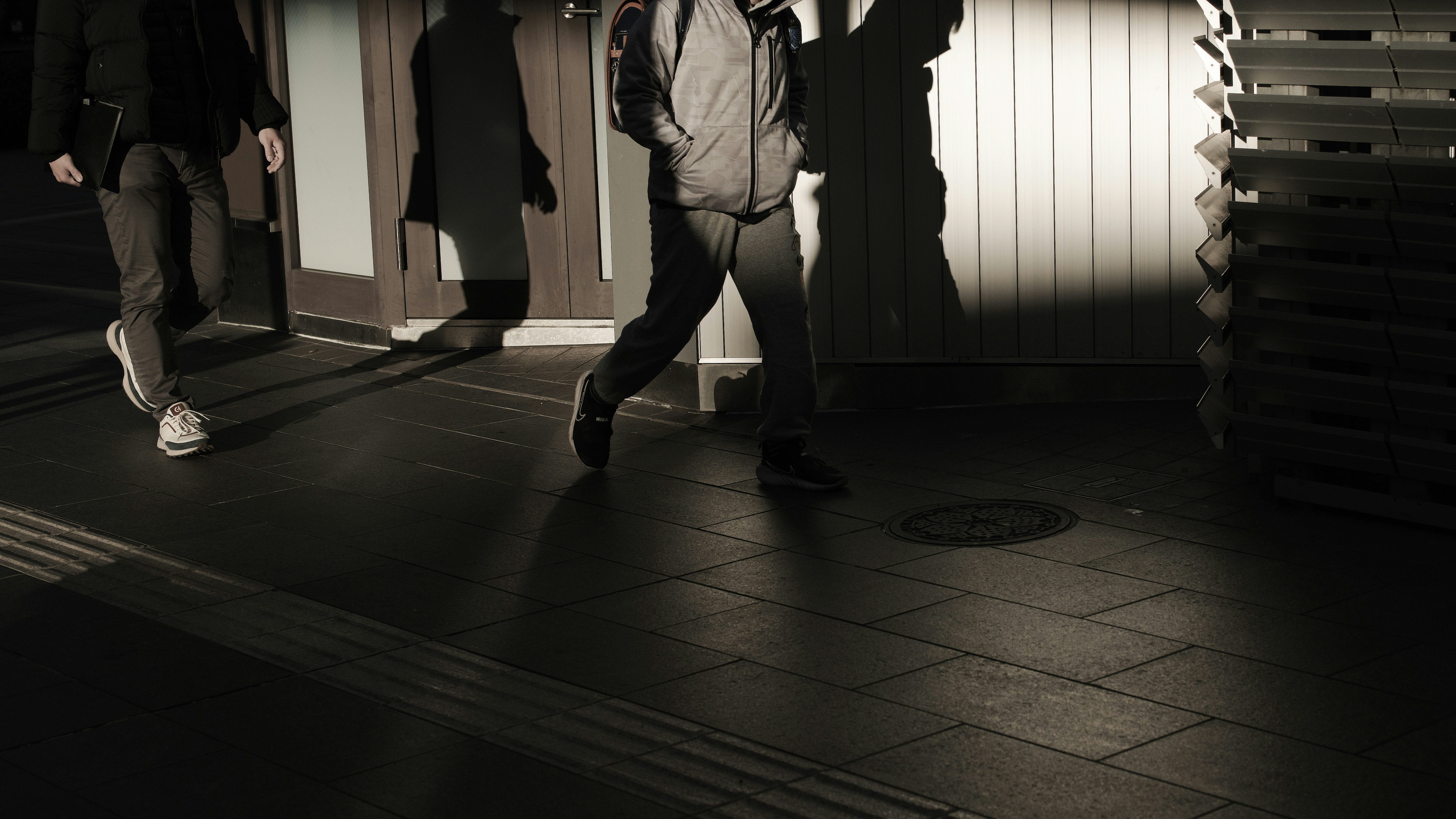 六本木通りの夜の歩道を歩く人々のシルエット