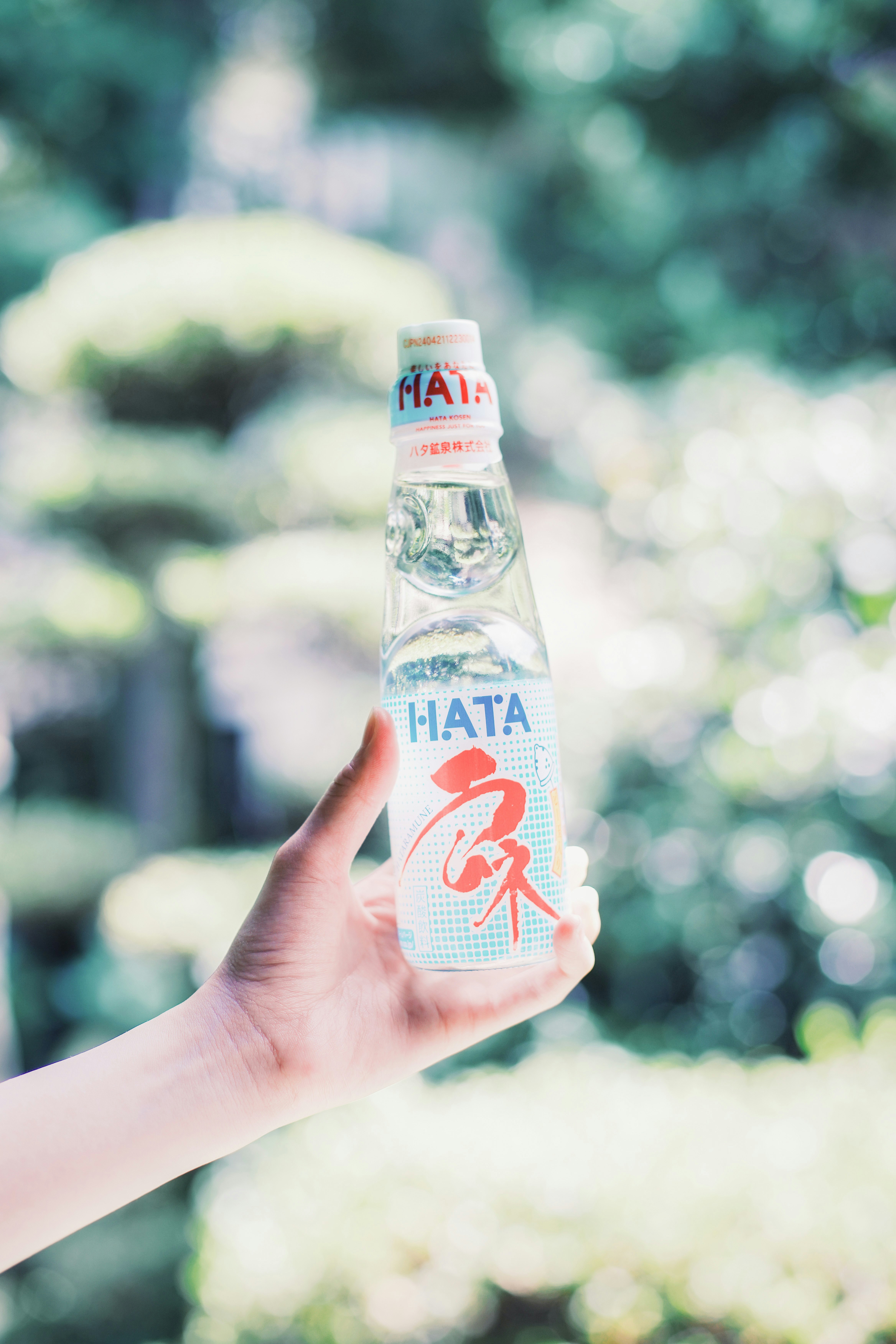 close-up of a hand holding a carbonated drink bottle