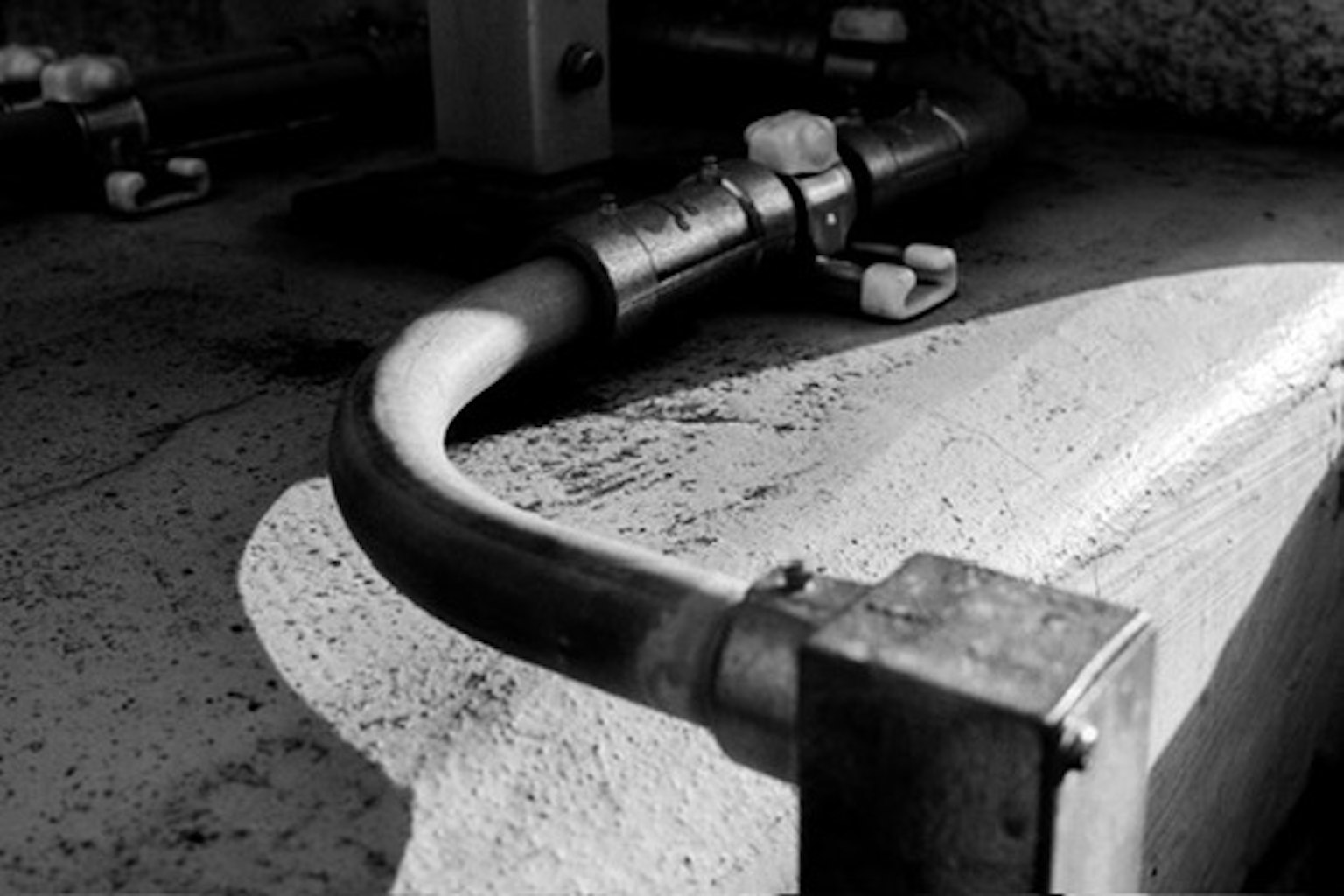 Gros plan sur un tuyau en noir et blanc sur une surface en béton