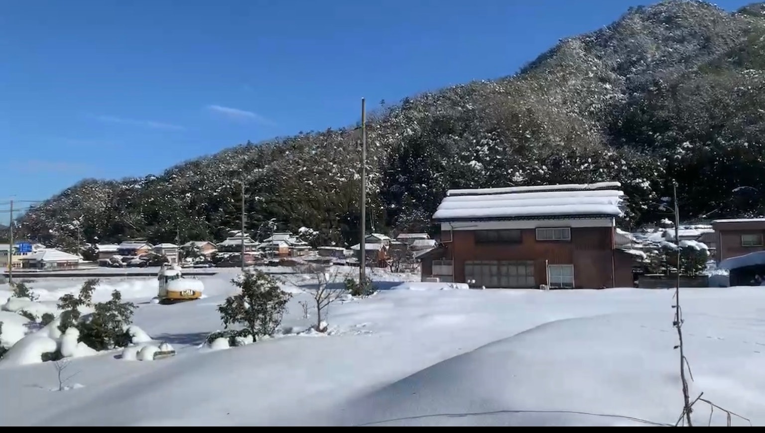 雪覆蓋的山脈和房屋的風景晴朗的藍天