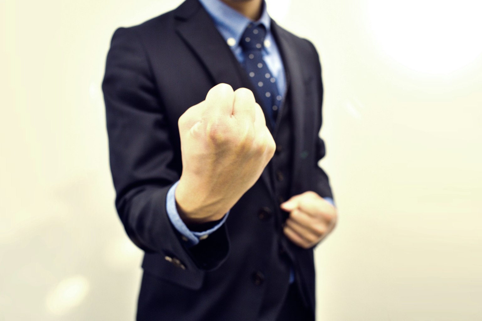 Un uomo in giacca che forma un pugno