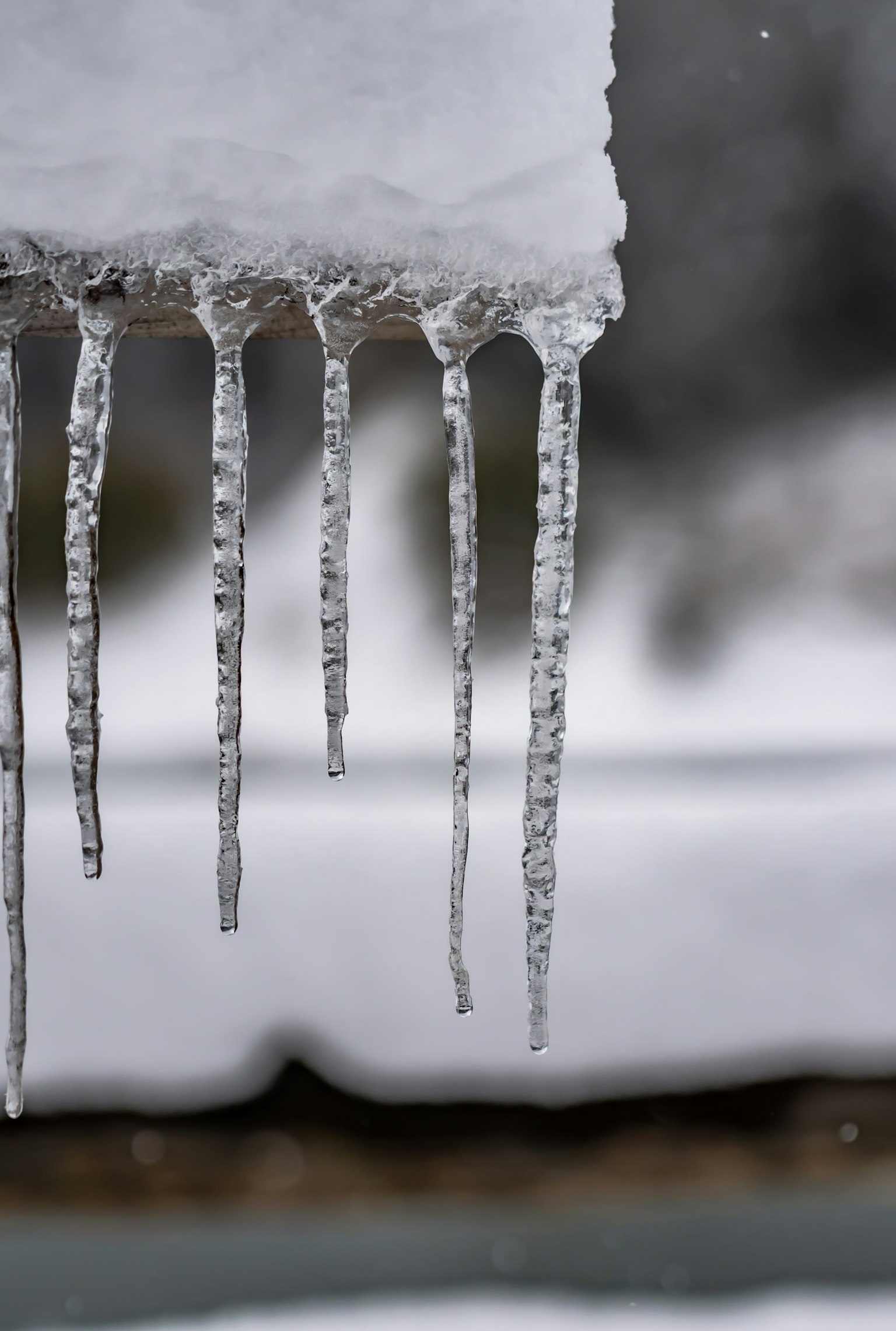 Winterlandschaft mit Eiszapfen, die von einer schneebedeckten Fläche hängen