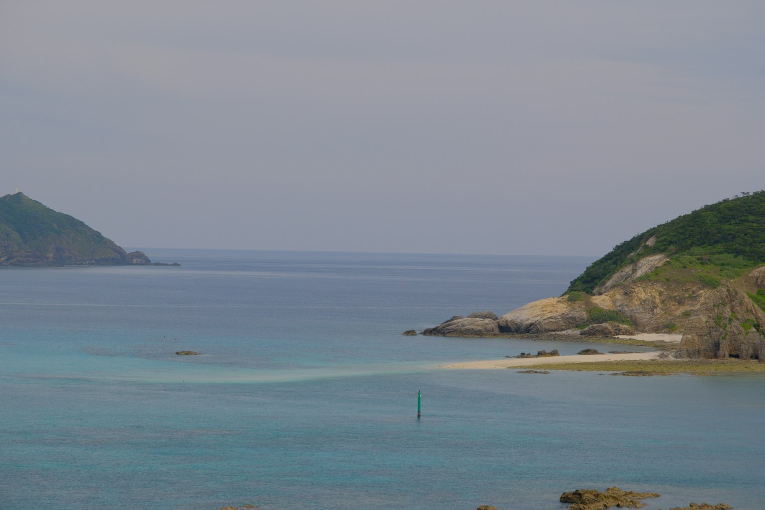 Mare calmo con colline verdi sullo sfondo
