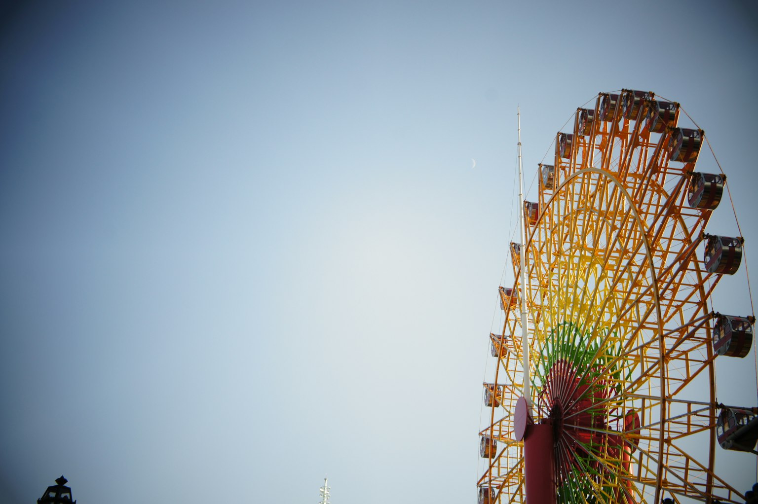 Part of a Ferris wheel against a blue sky