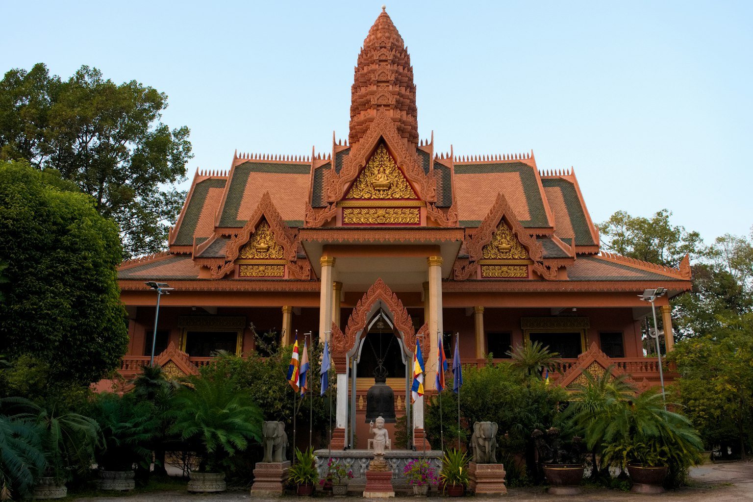 Facciata di un tempio cambogiano tradizionale circondata da vegetazione lussureggiante