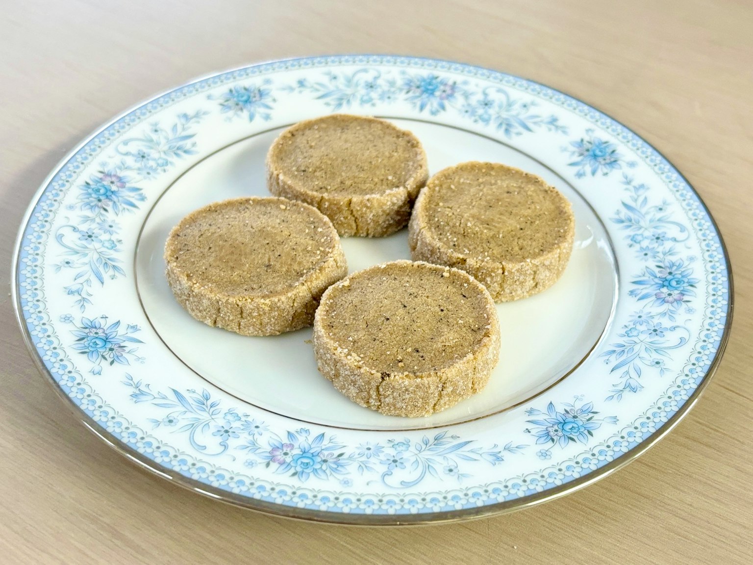 Quattro biscotti rotondi disposti su un piatto bianco decorativo