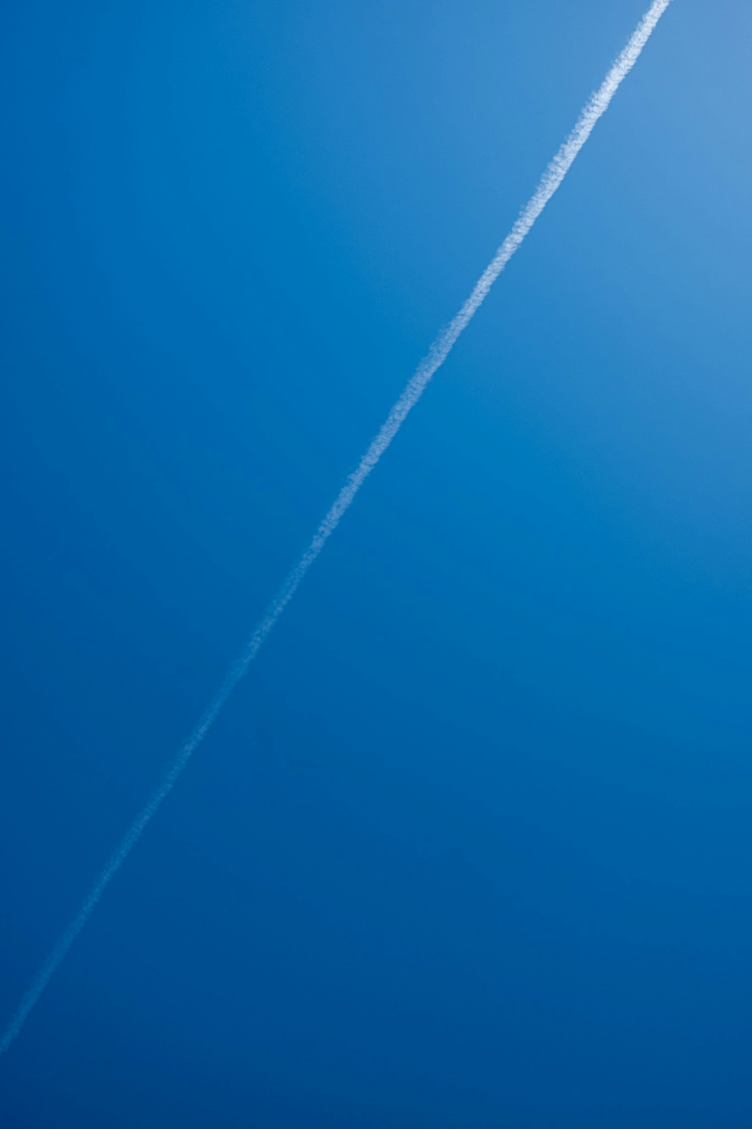 在晴朗的藍天中形成直線的白色飛機雲