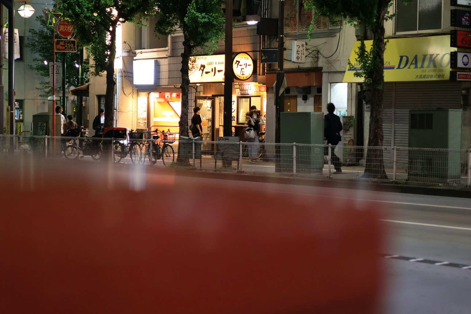 มุมมองที่พร่ามัวของถนนในเวลากลางคืนพร้อมผู้คนและร้านค้า