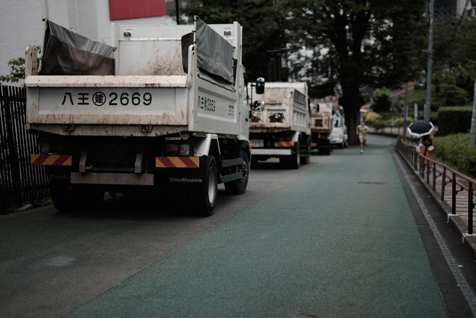 Blick auf mehrere Lastwagen, die entlang einer Stadtstraße geparkt sind
