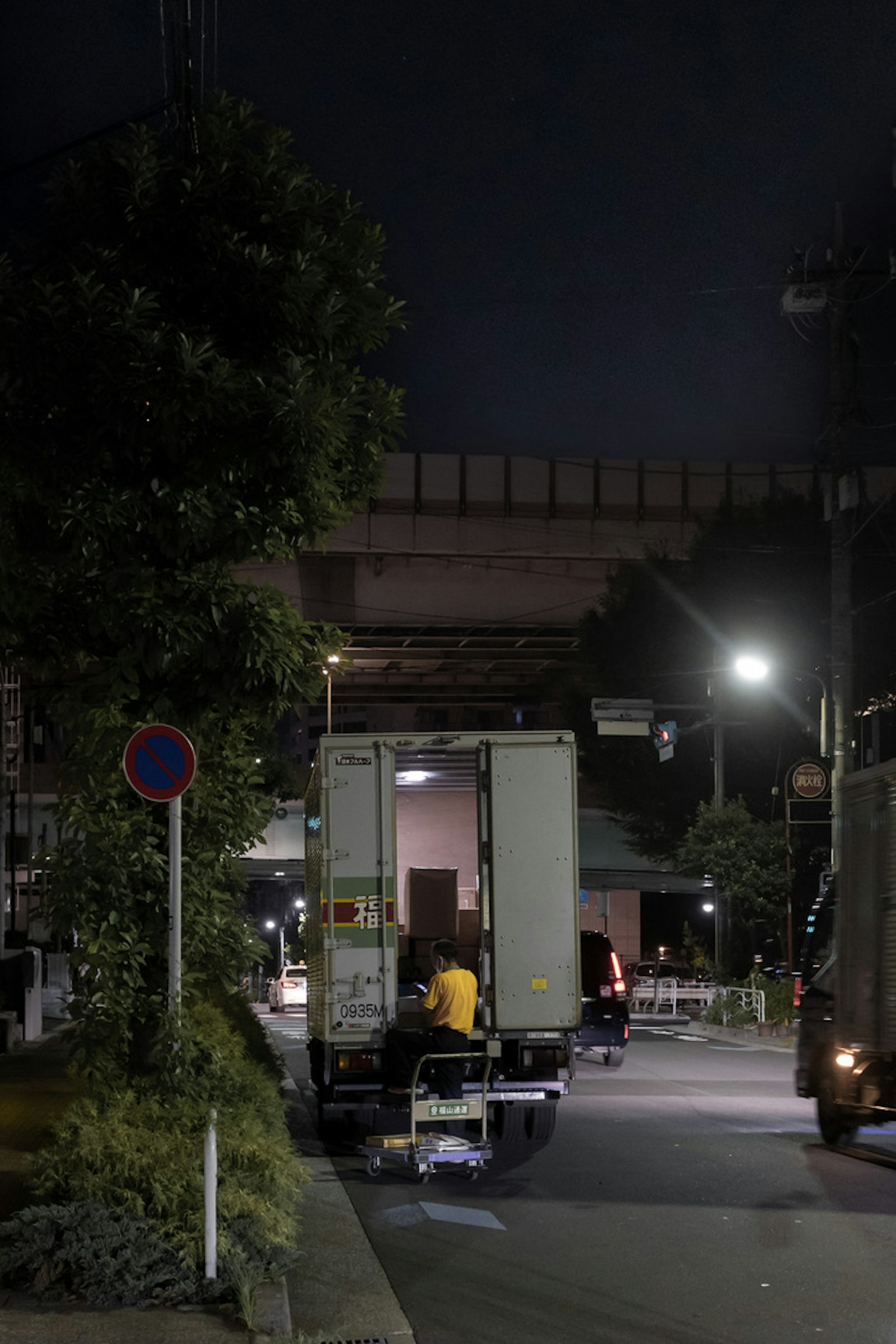 A truck loading cargo in a city at night