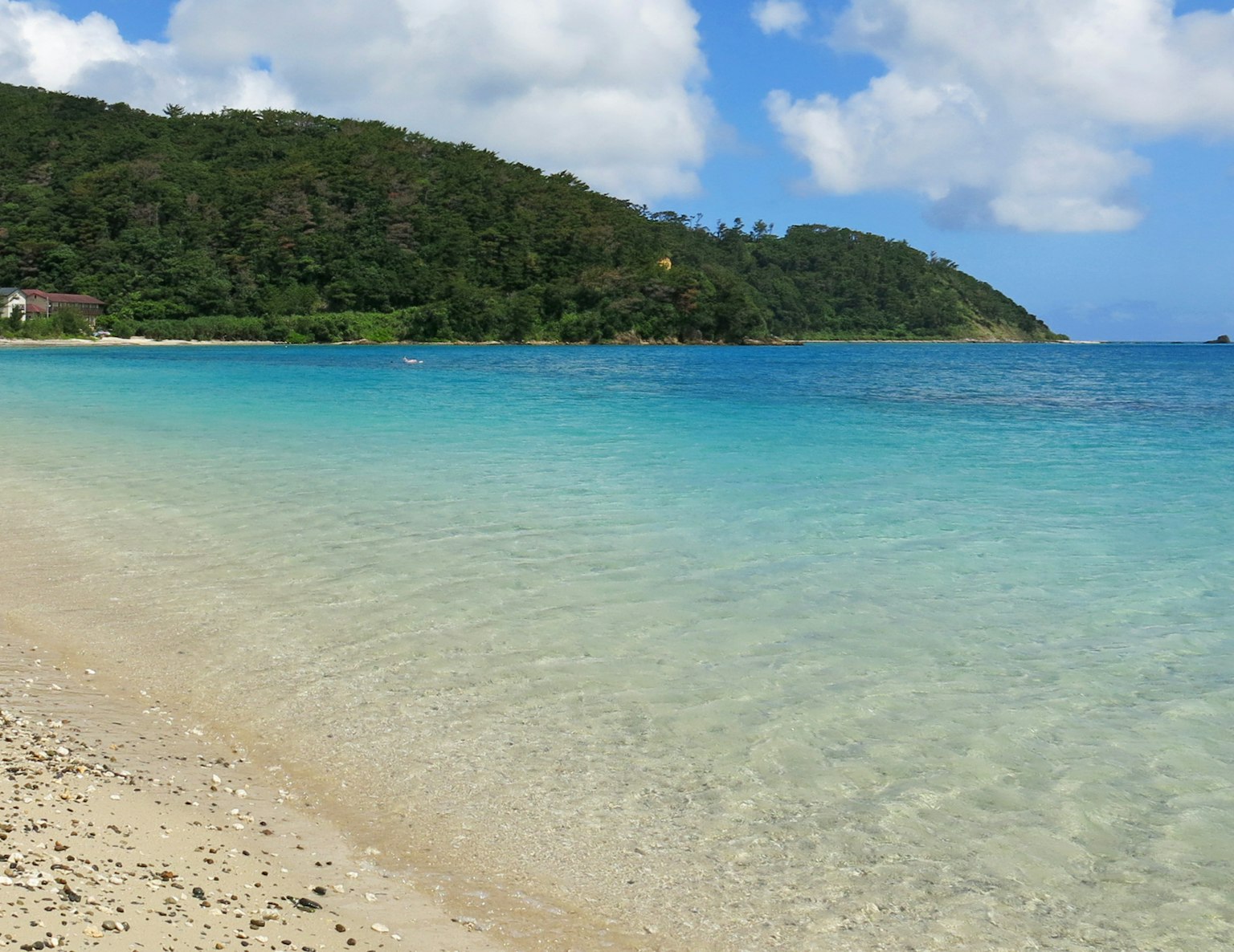 Scène de plage magnifique avec une eau bleue claire et un rivage de sable blanc