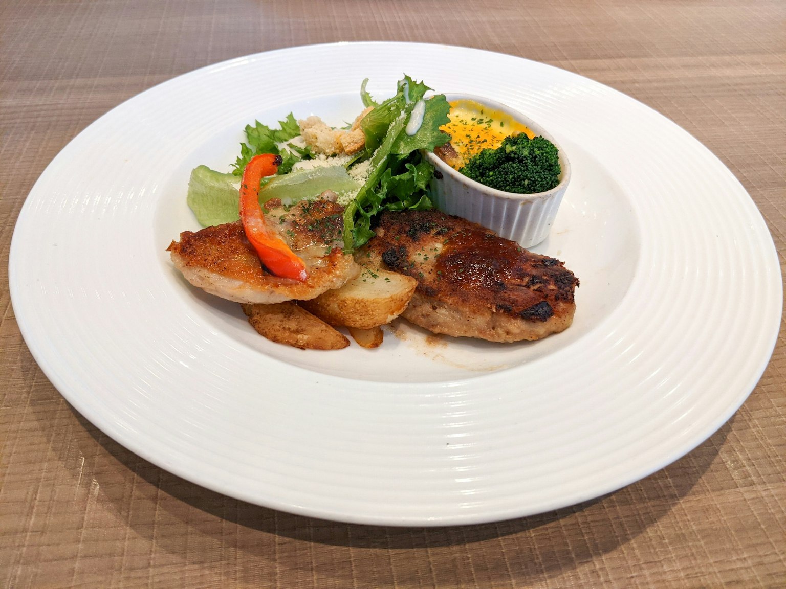 Một đĩa thức ăn ngon gồm gà nướng với salad rau màu sắc khoai tây nướng và rau chân vịt