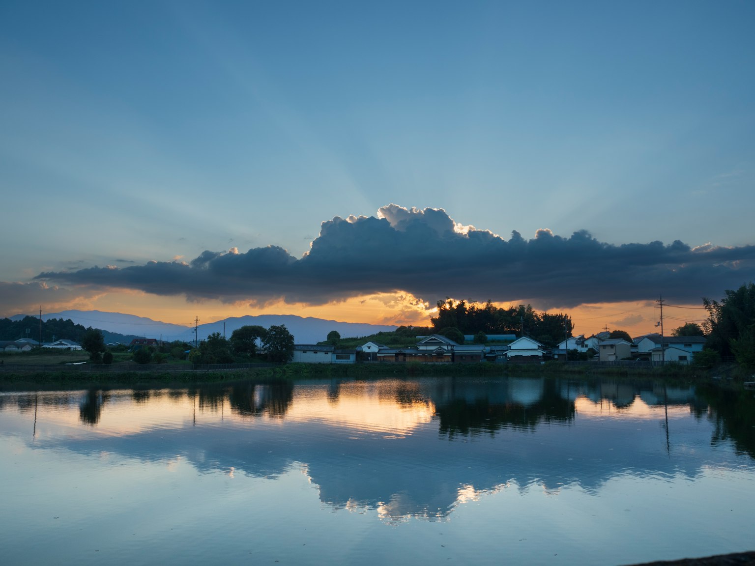 Vue pittoresque d'un coucher de soleil sur un lac avec des nuages reflétés sur l'eau