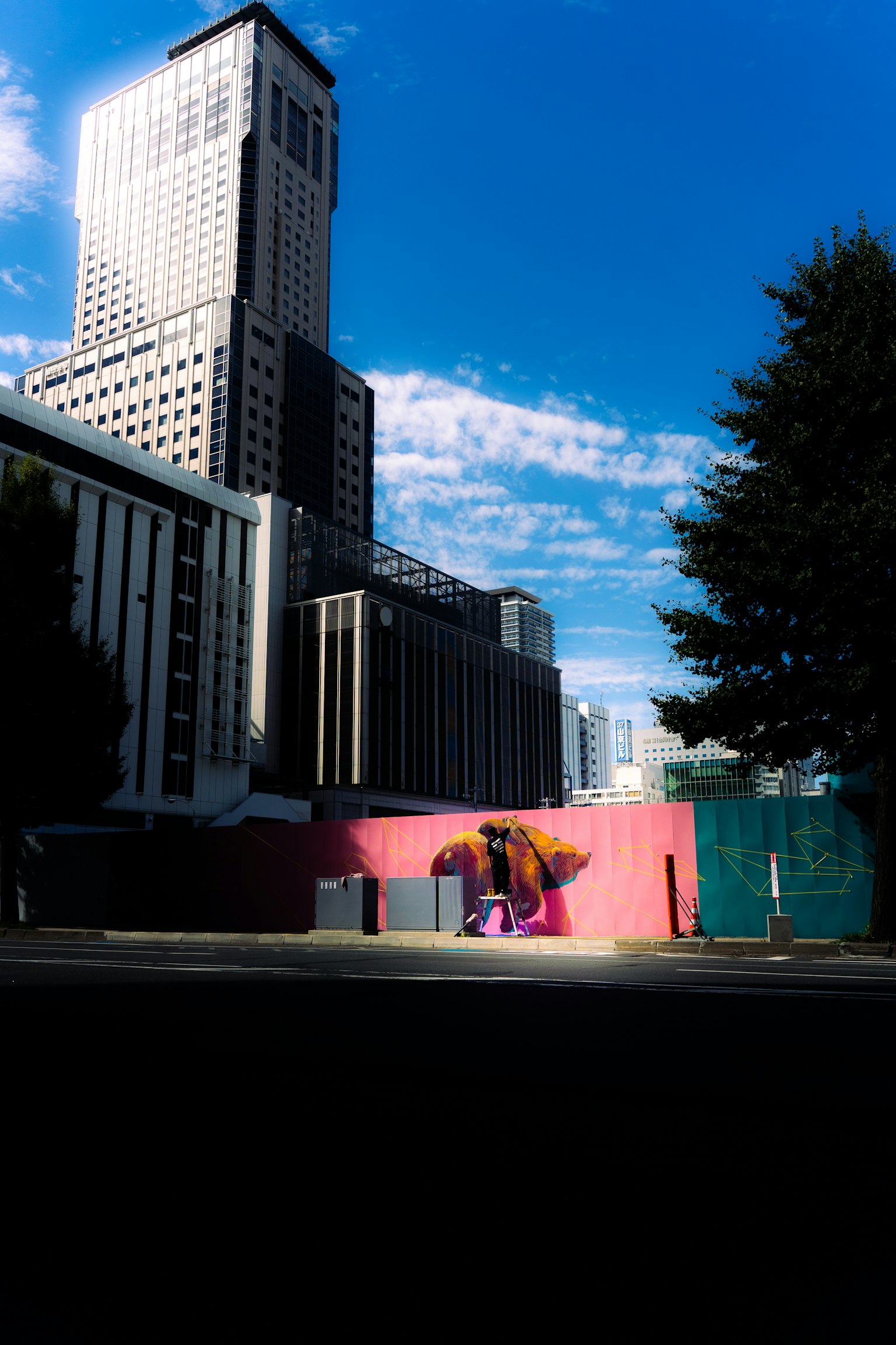 Grand bâtiment avec ciel bleu et mur rose avec art