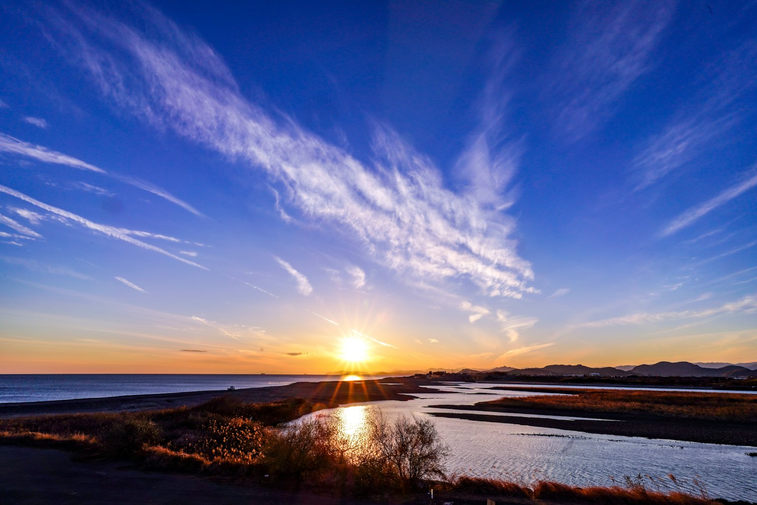 Tramonto suggestivo sull'oceano con riflessi nel fiume