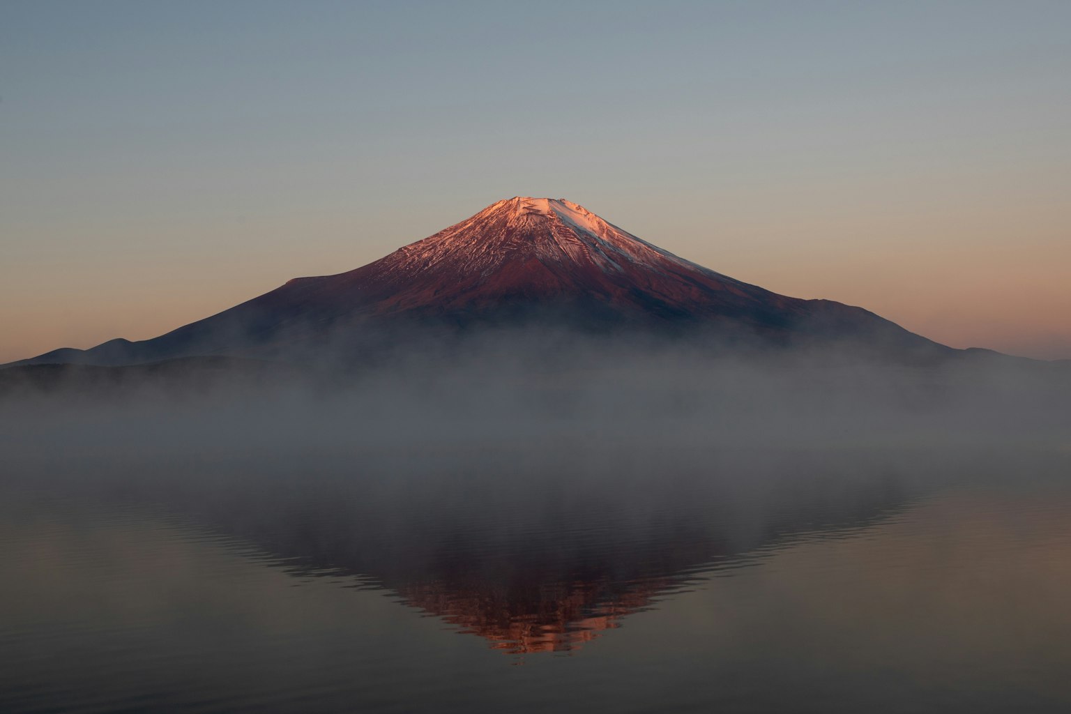 富士山の美しい朝焼けと霧の反射が湖面に映る風景