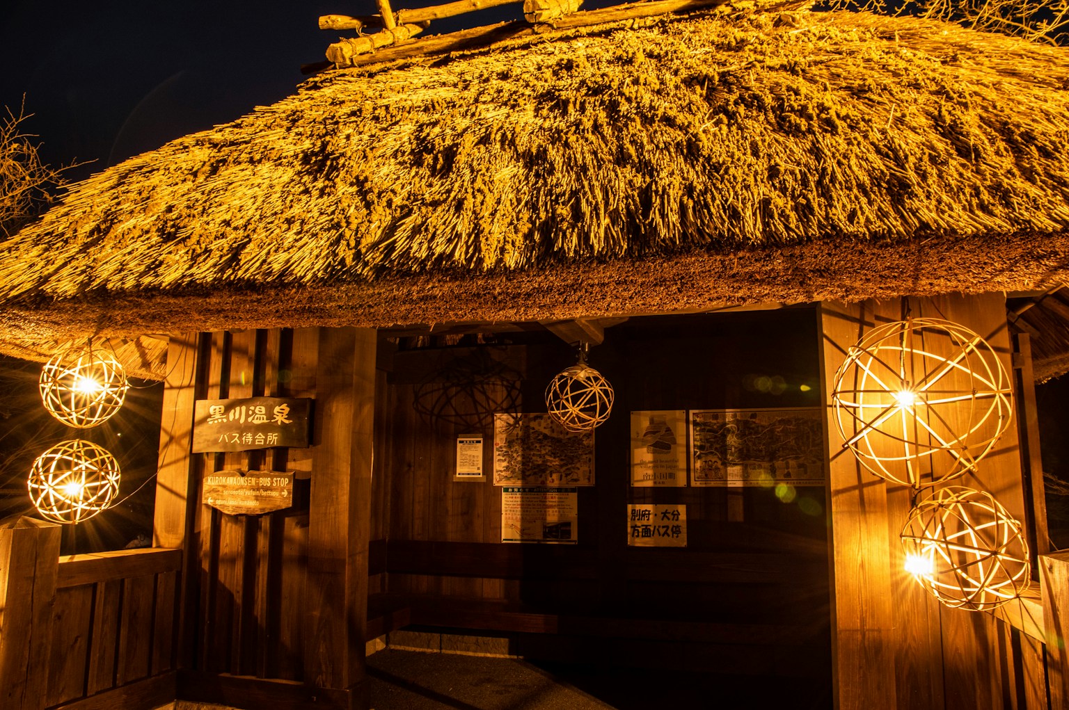 夜の古い茅葺き屋根の建物の外観 照明が柔らかく温かい雰囲気を演出