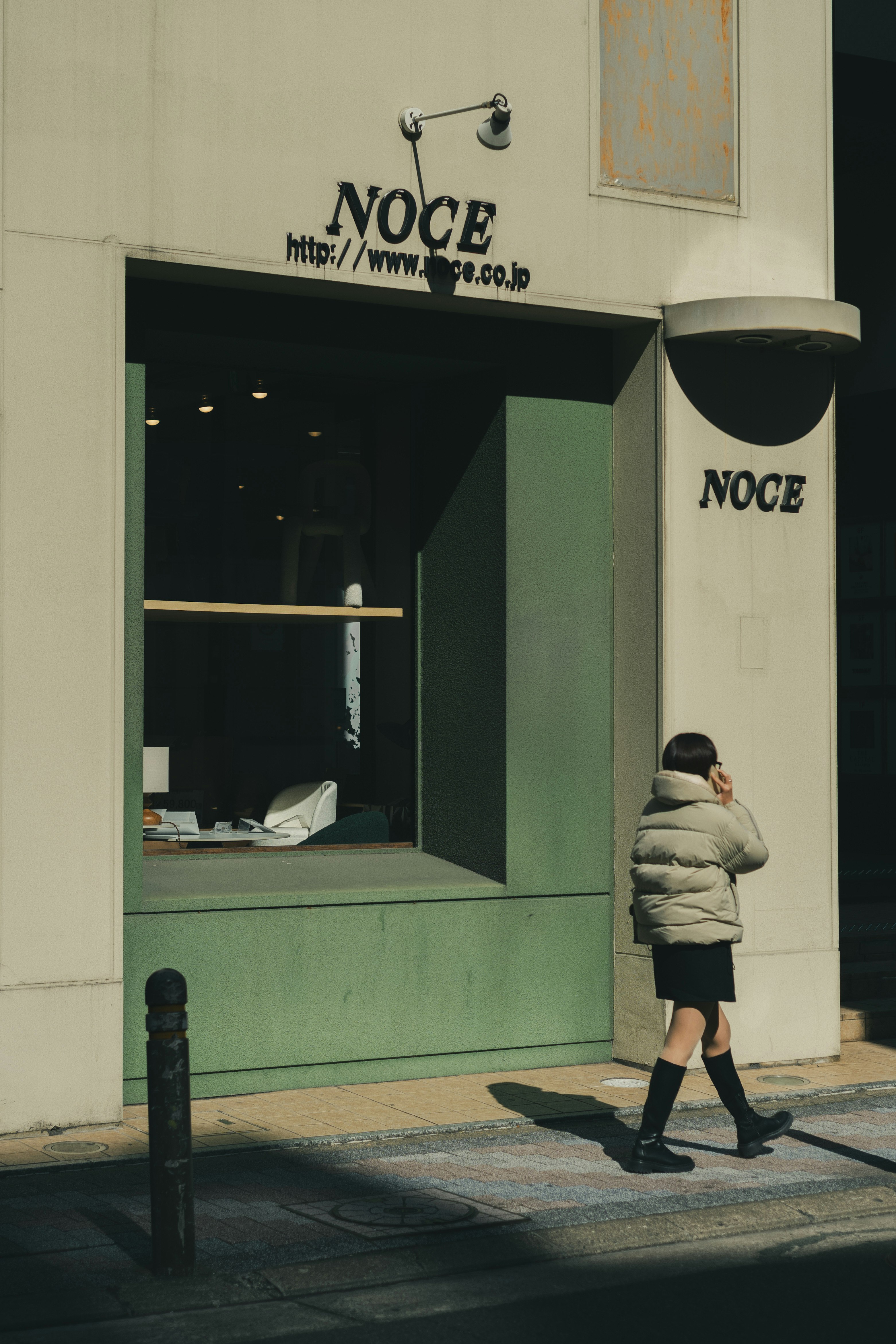 Fachada de la tienda NOCE en Tenjin, Fukuoka con un transeúnte