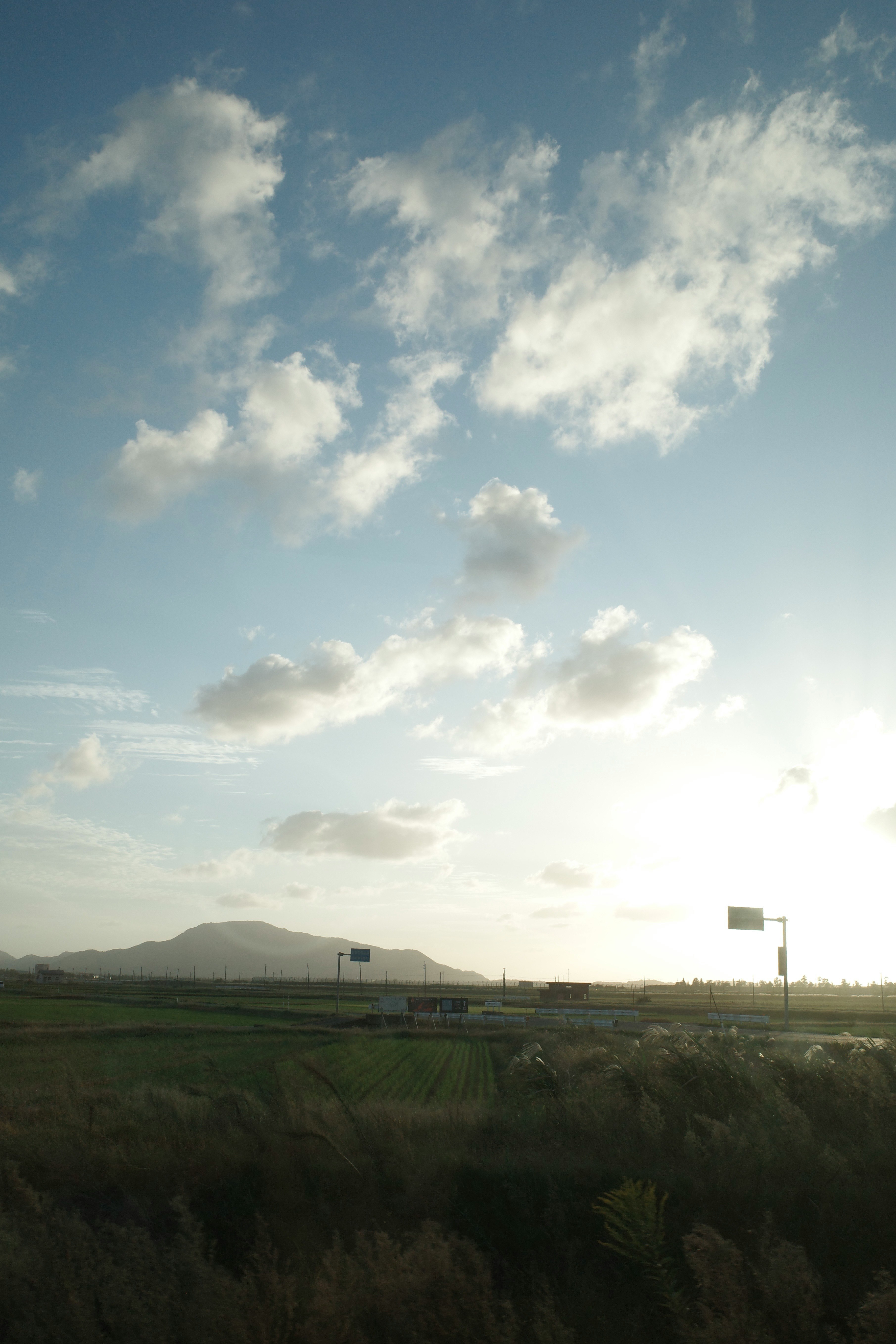 草原と遠くの山並みが広がる夕景の空