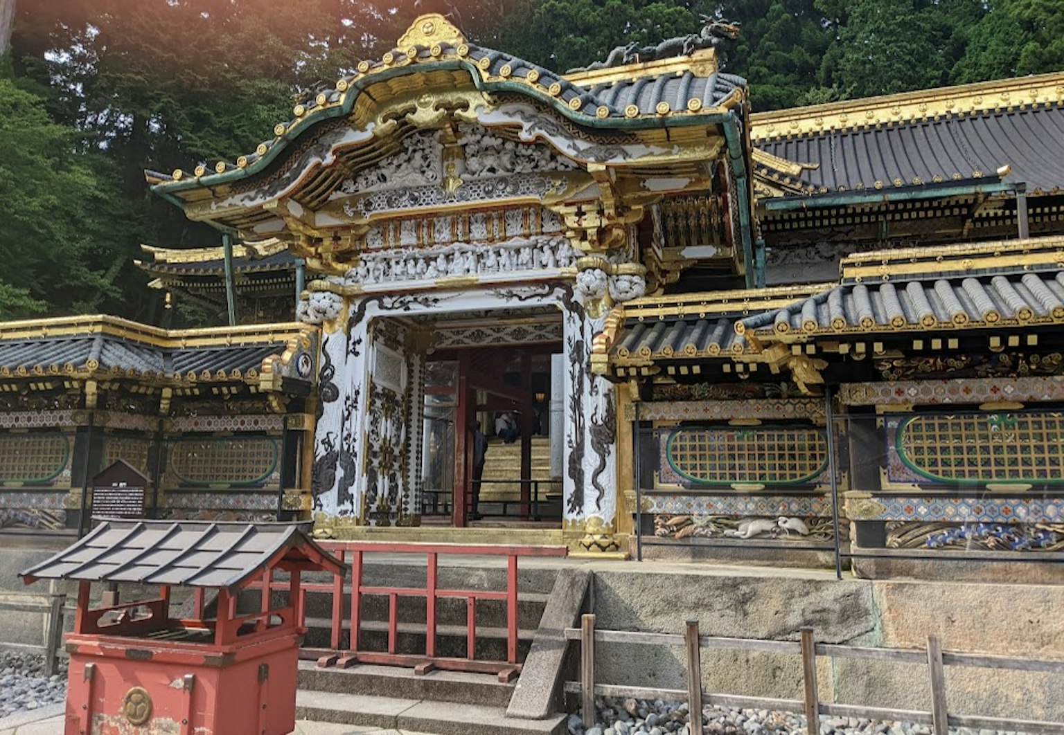 Estructura decorada de manera elaborada del santuario Toshogu de Nikko rodeada de vegetación exuberante