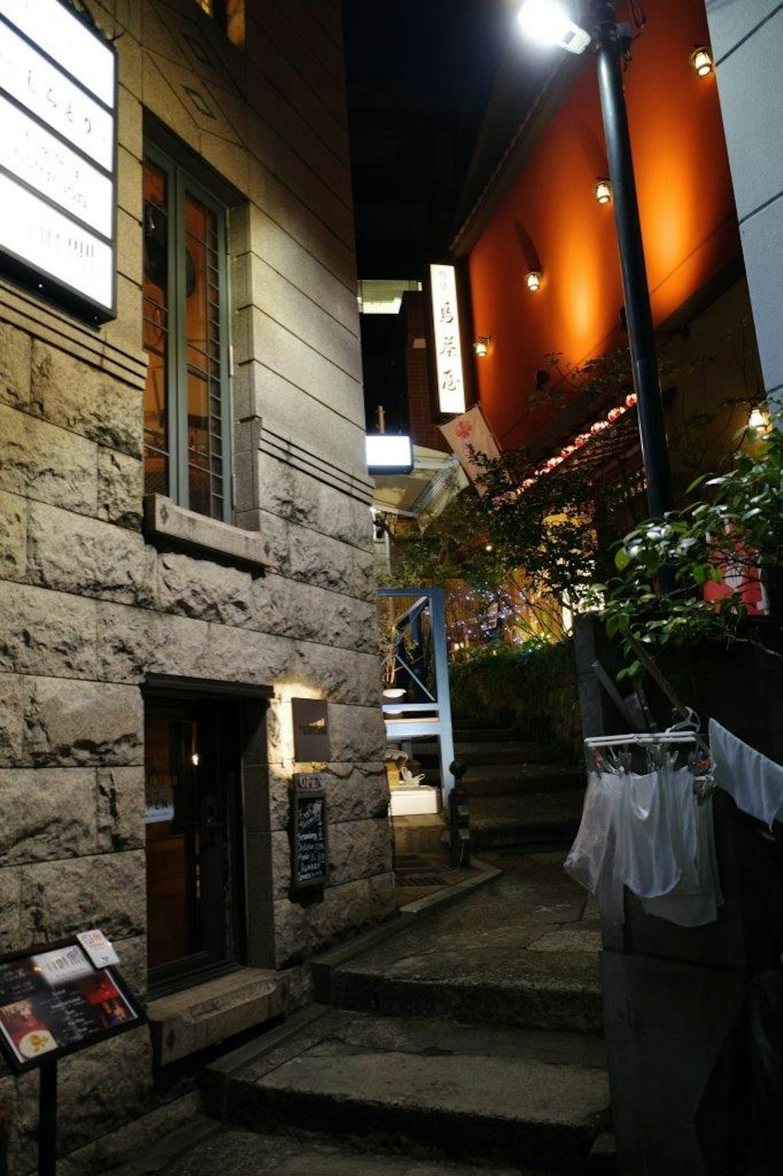 Edificio in pietra di notte con illuminazione calda e un sentiero stretto