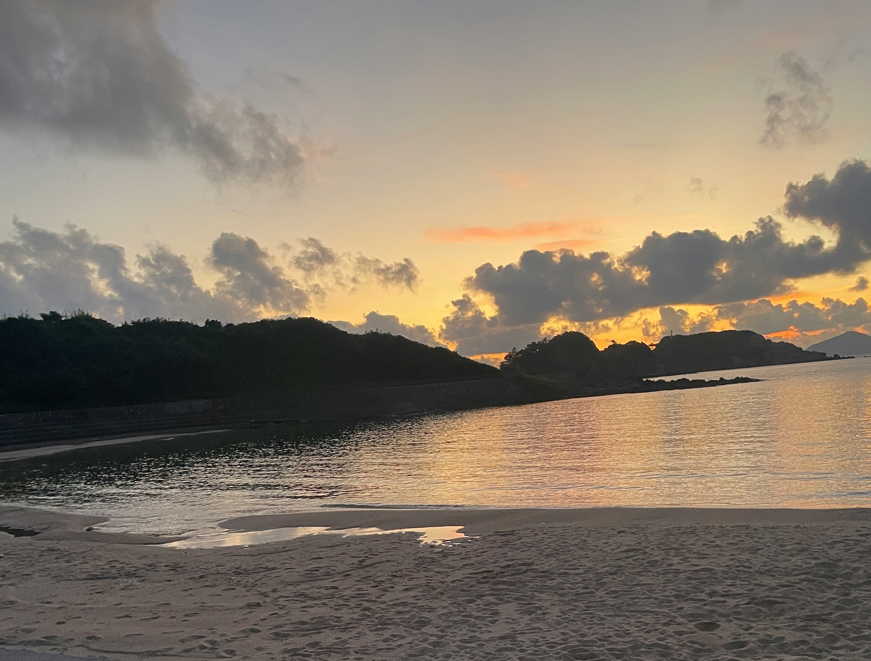 夕暮れの海岸で広がる波と空