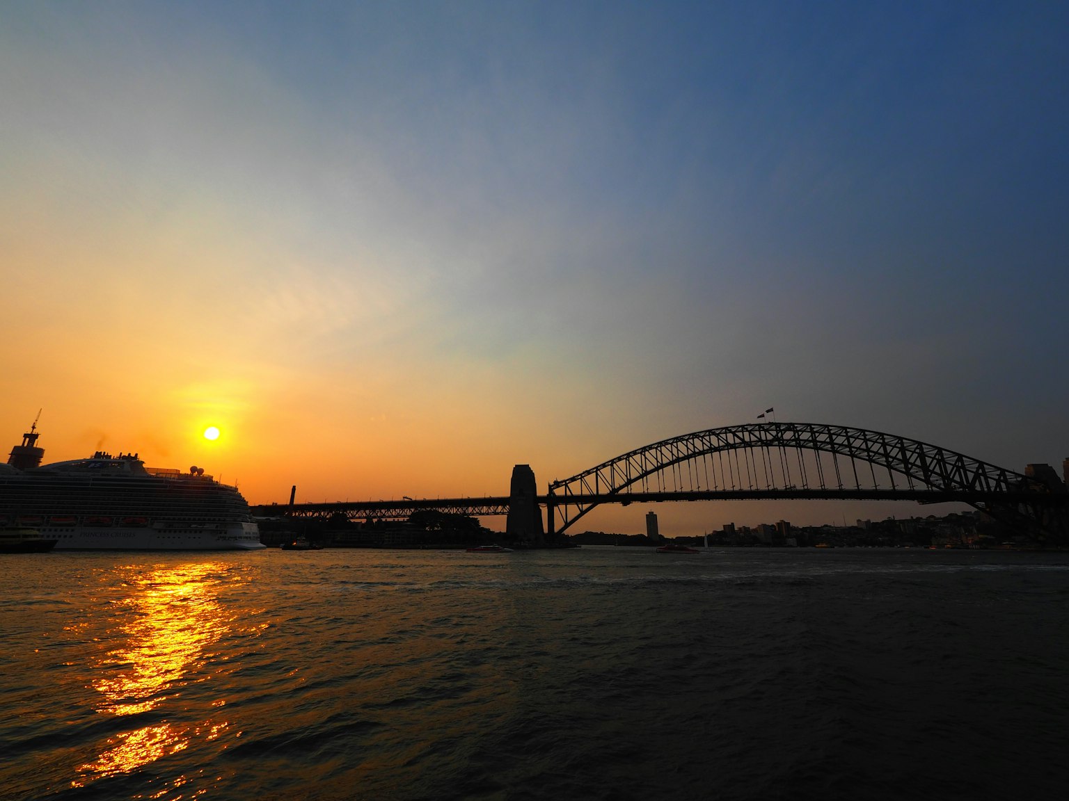 Ponte di Sydney silhouettato contro un tramonto sull'acqua