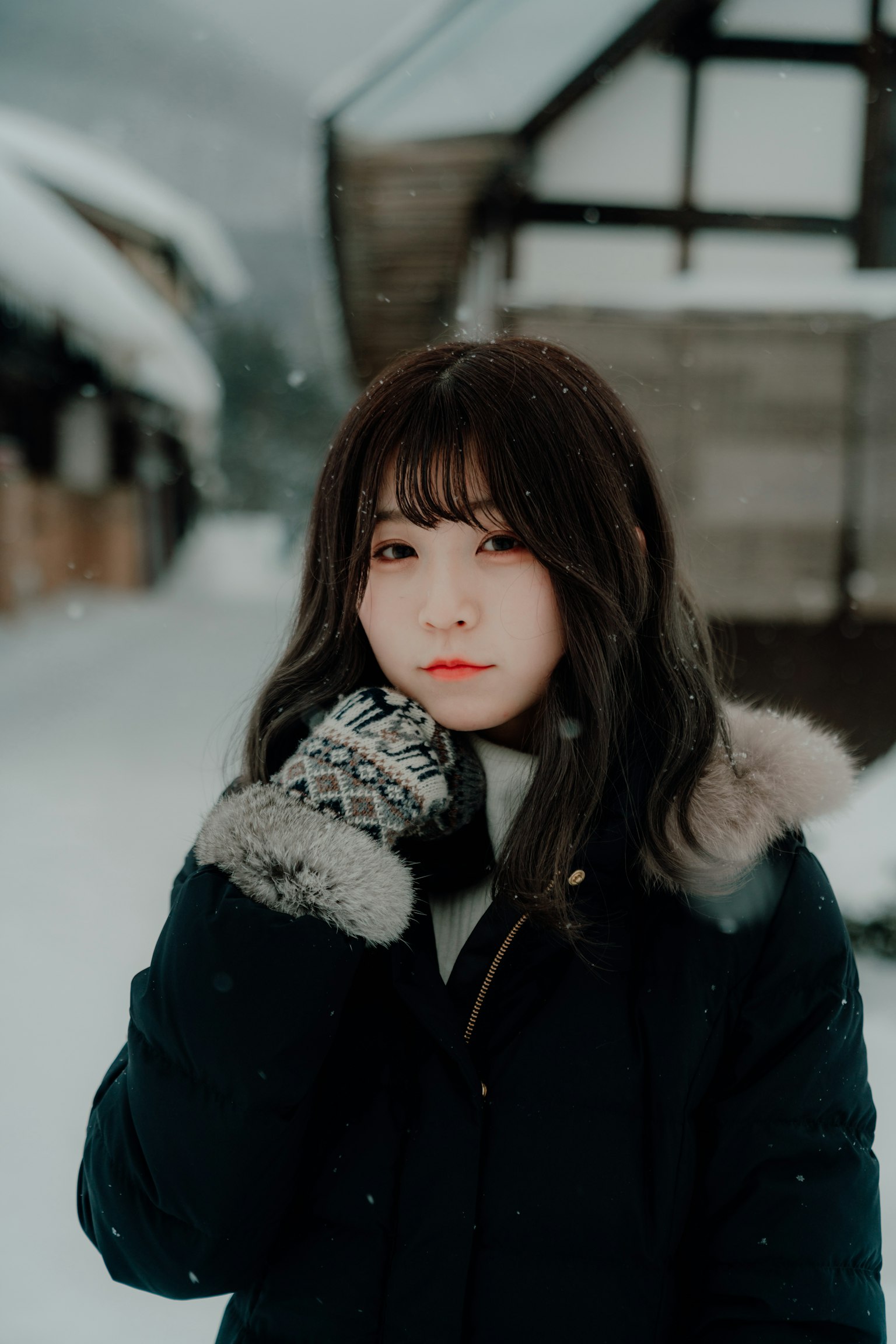 Ritratto di una donna nella neve invernale che tiene il viso