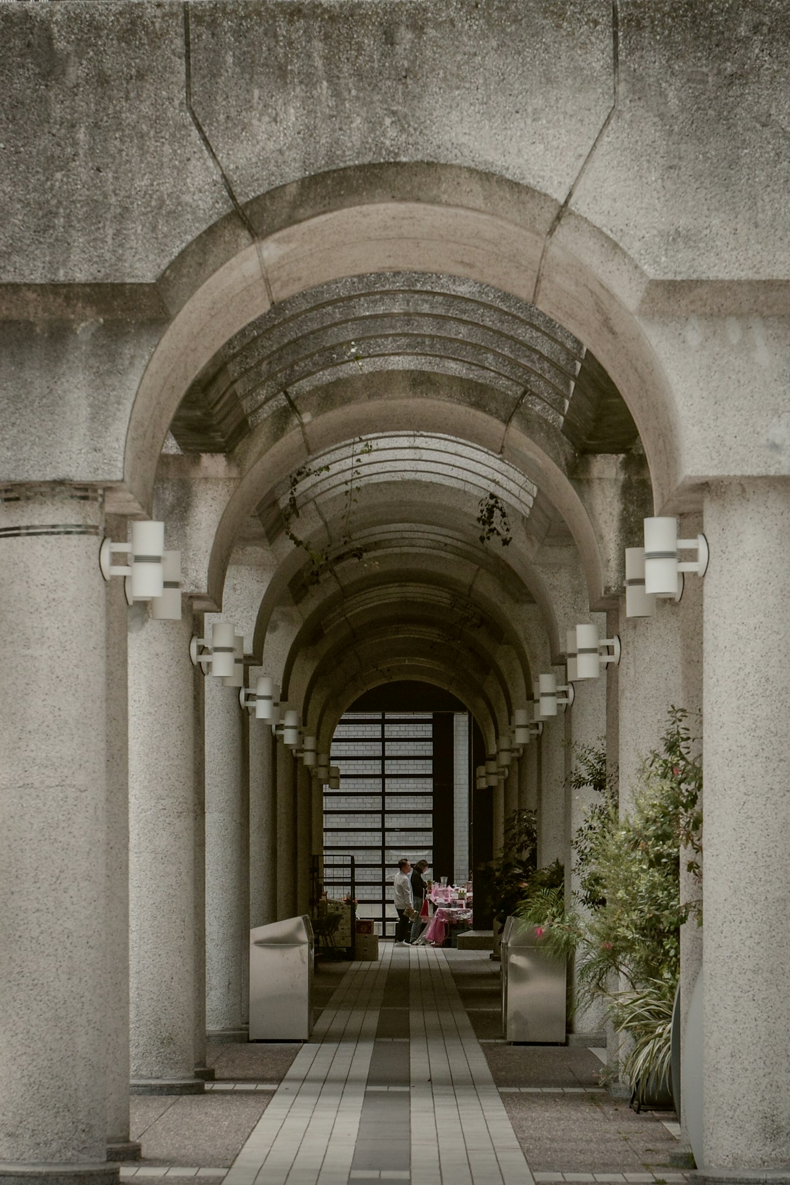 Image d'un long couloir avec des piliers en arche et un éclairage doux