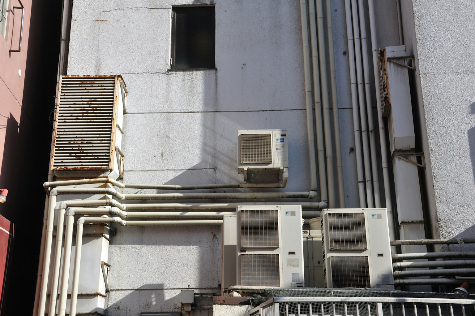 Unités de climatisation et tuyaux sur le côté d'un bâtiment
