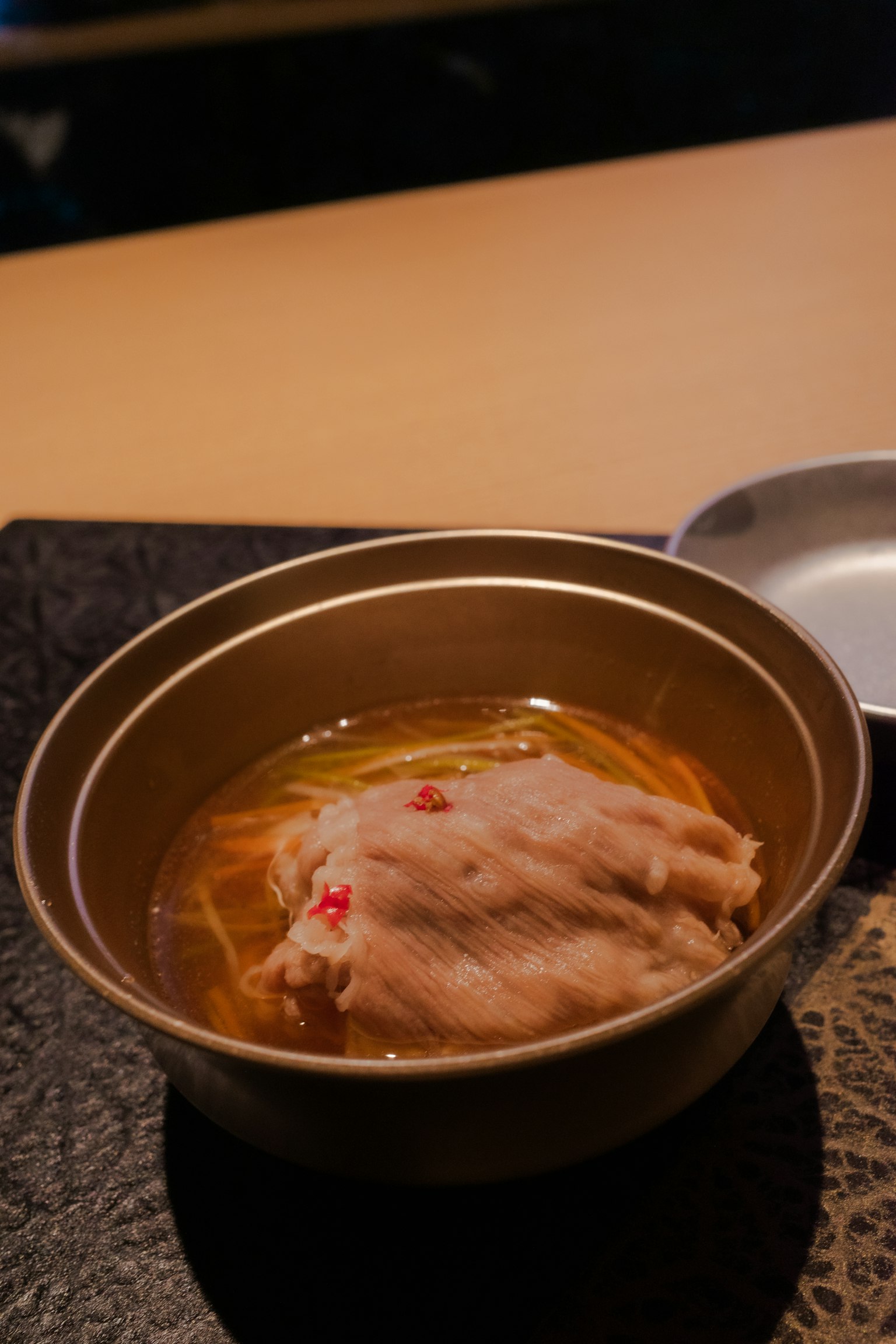 金色碗中的肉片和湯