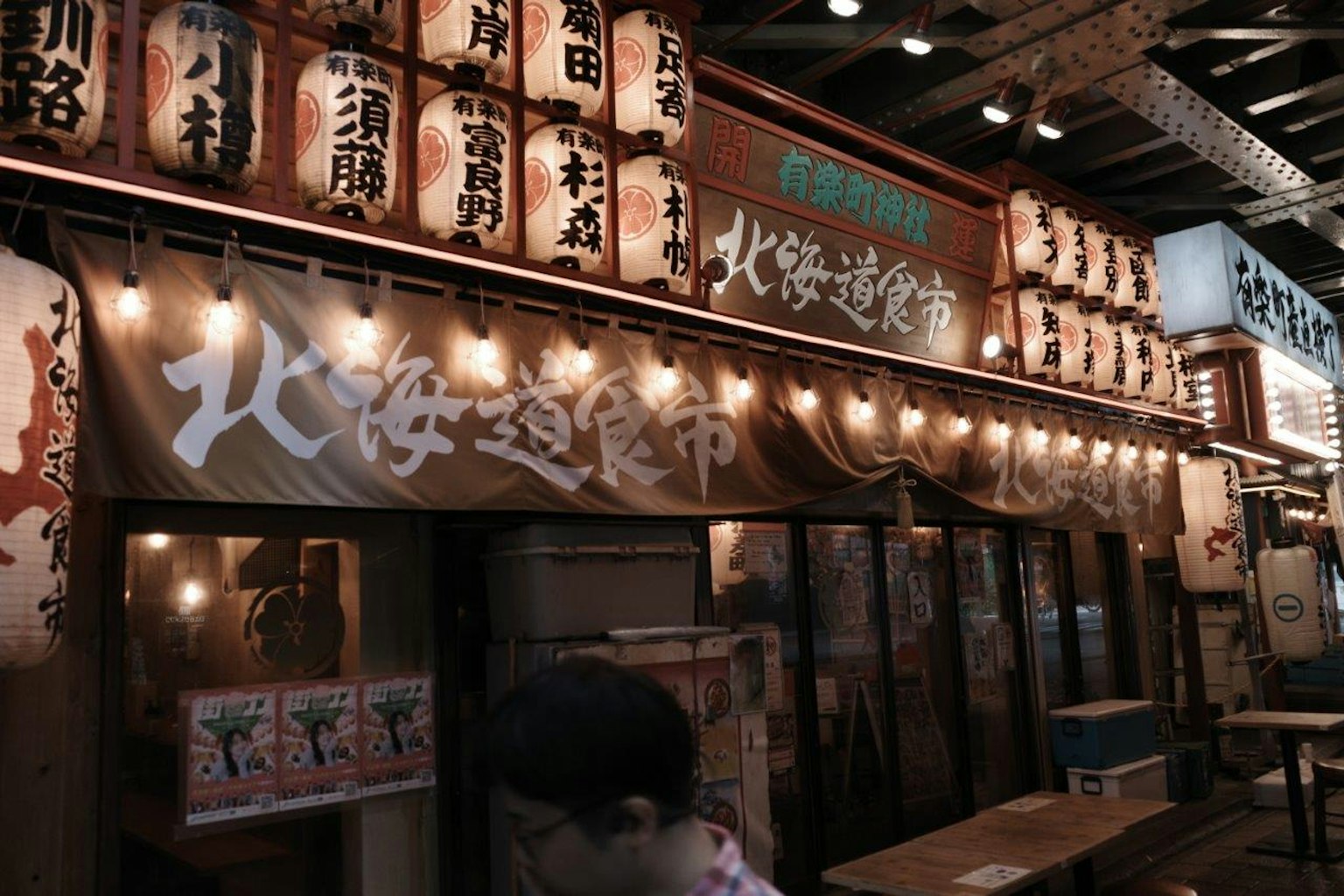 Extérieur vibrant d'un restaurant japonais avec des lanternes et des enseignes lumineuses