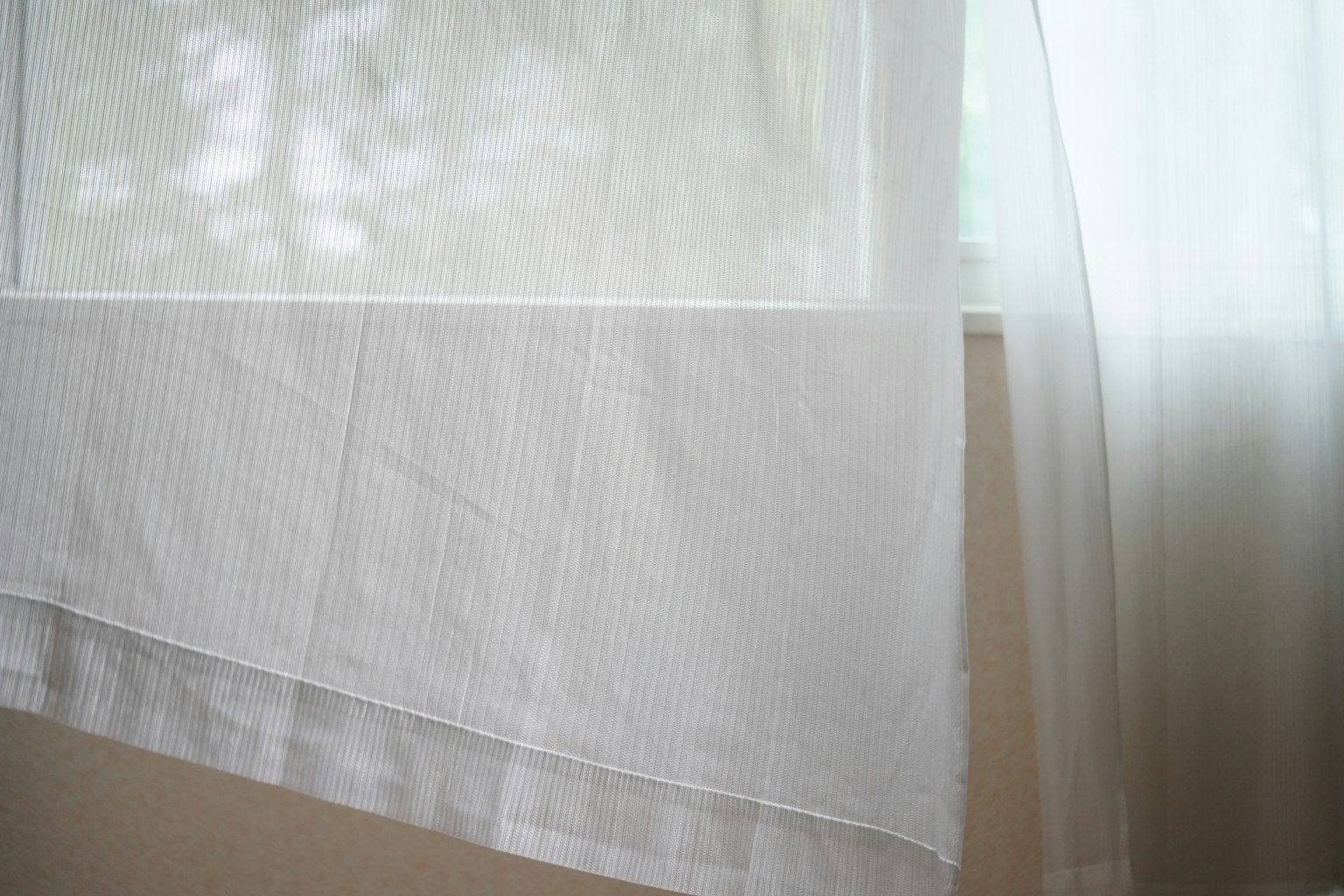 Cortina blanca y tela transparente colgando en una ventana