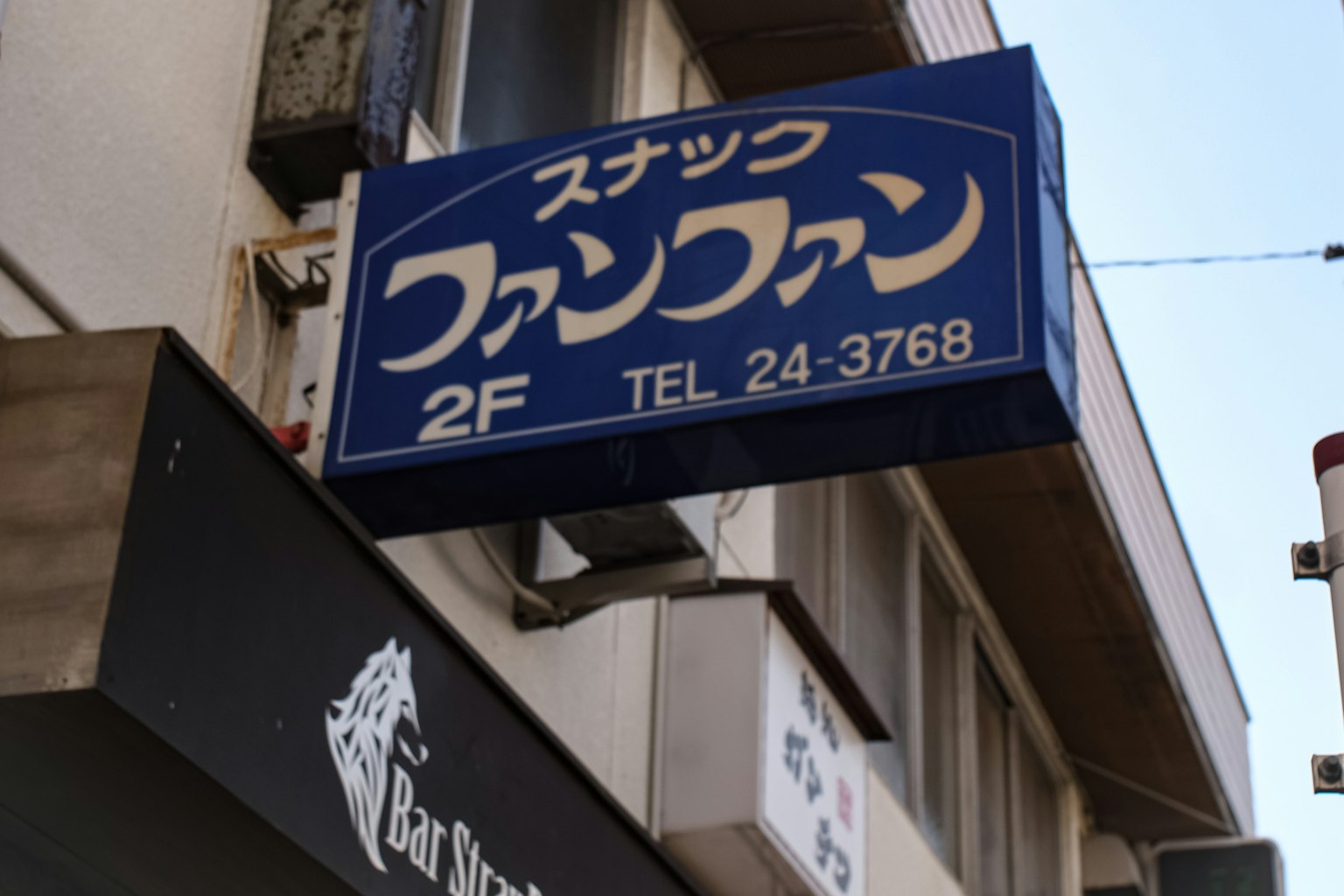 Papan biru untuk Snack Fan Fan dengan nomor telepon