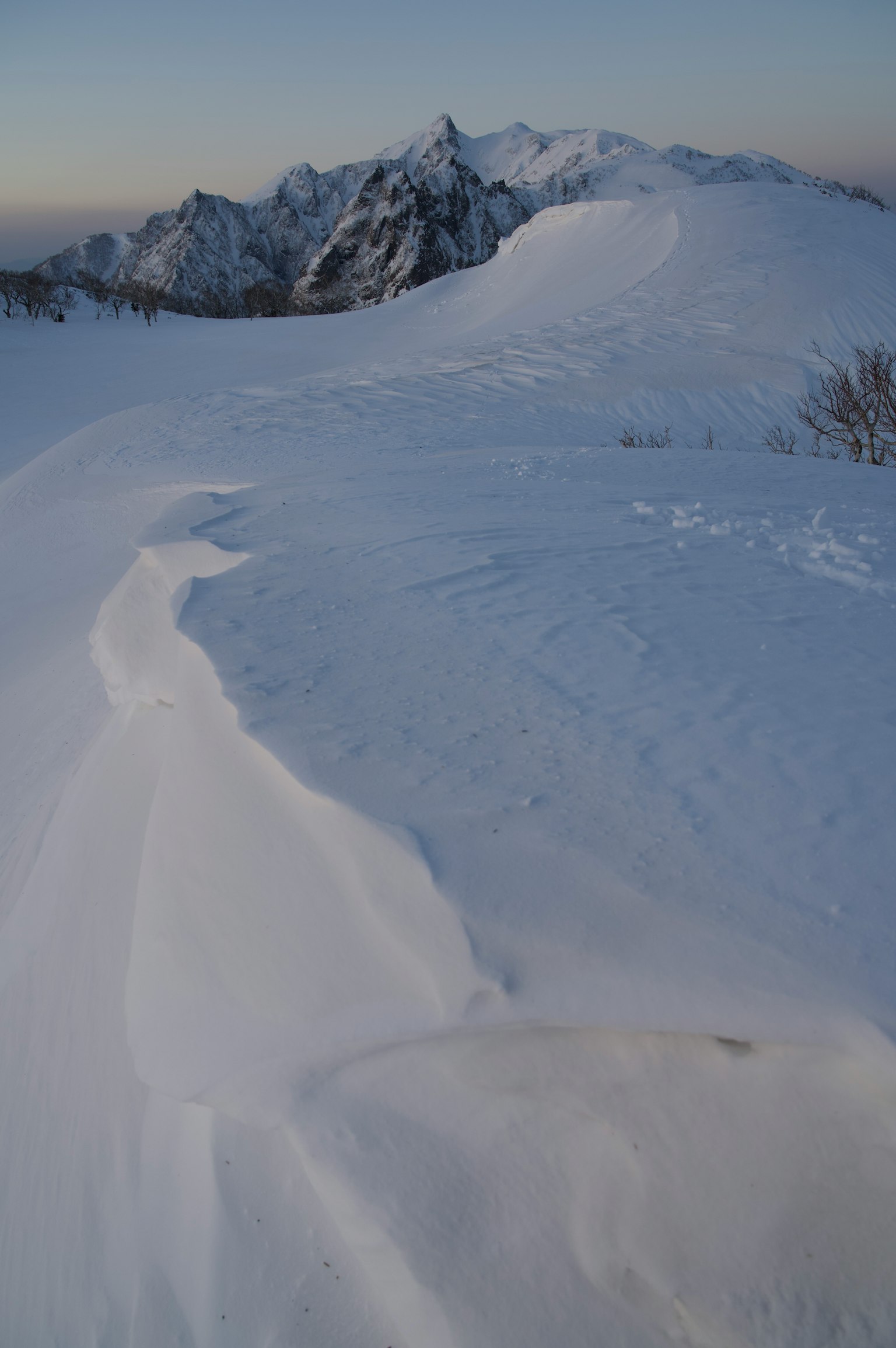 Paysage de montagne enneigé avec des drifts de neige lisses