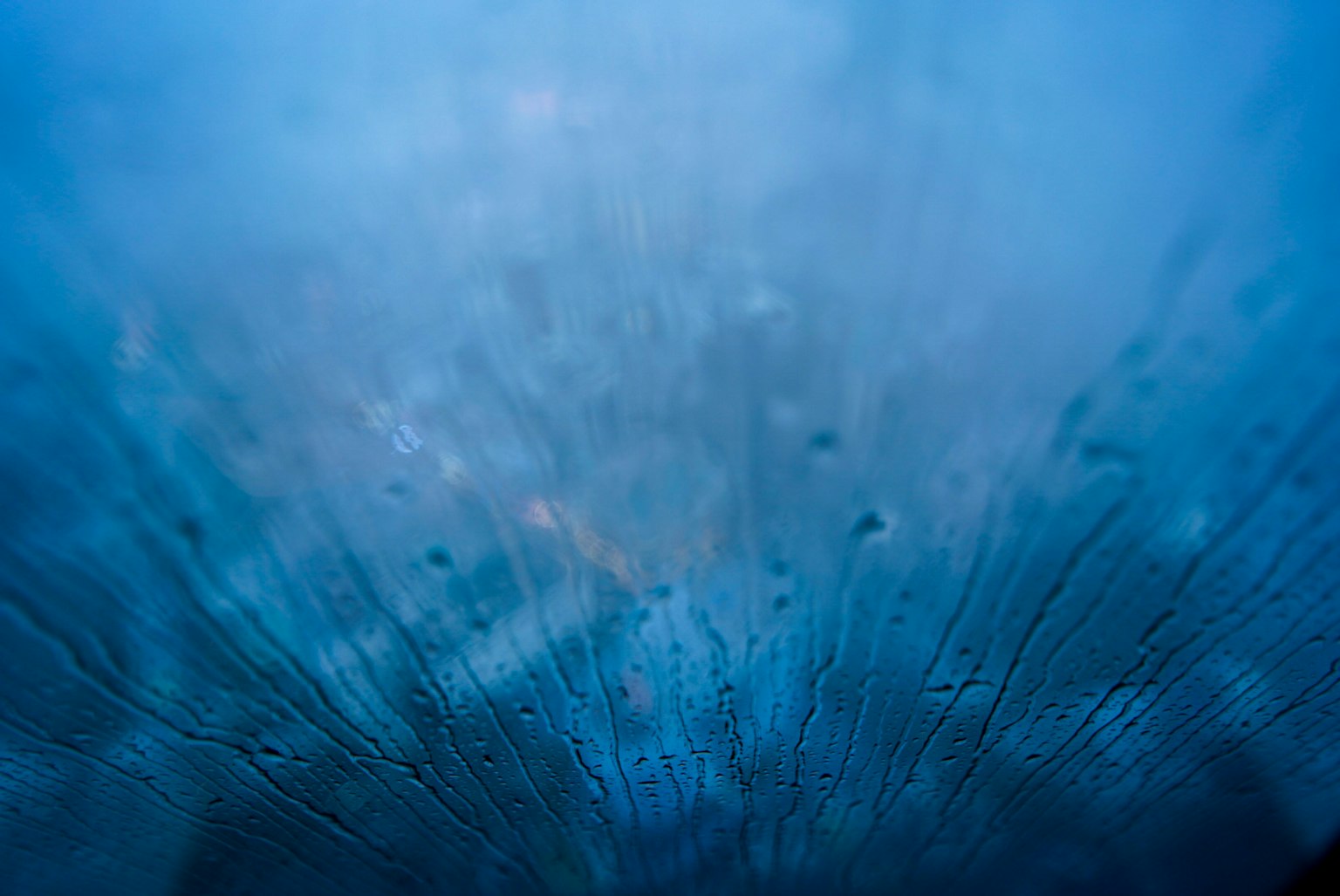 Nahaufnahme eines Fensters mit blauen Wassertropfen
